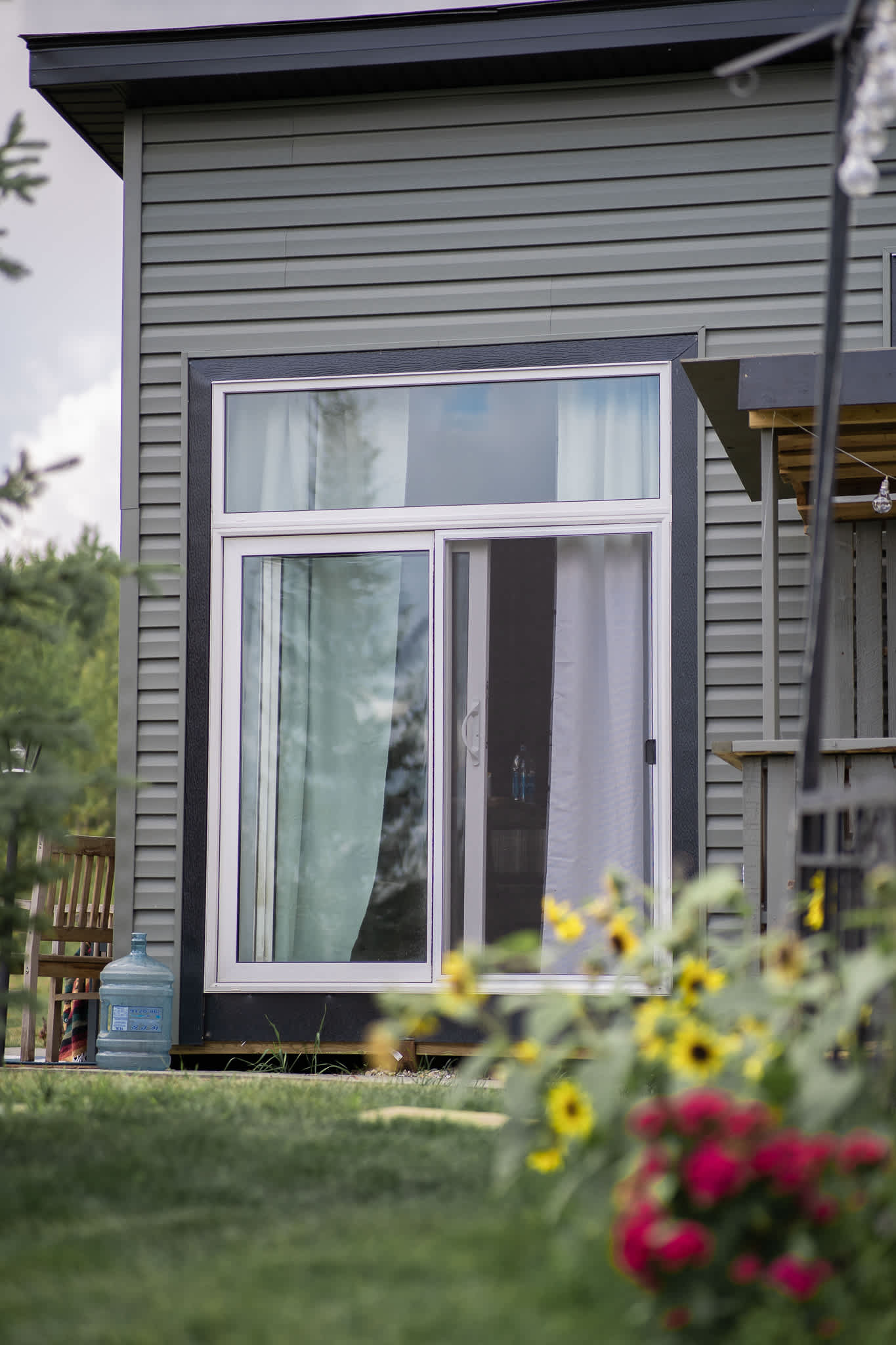 Sliding glass doors on the side of the house that lead out to the canopy/tent covered BBQ area