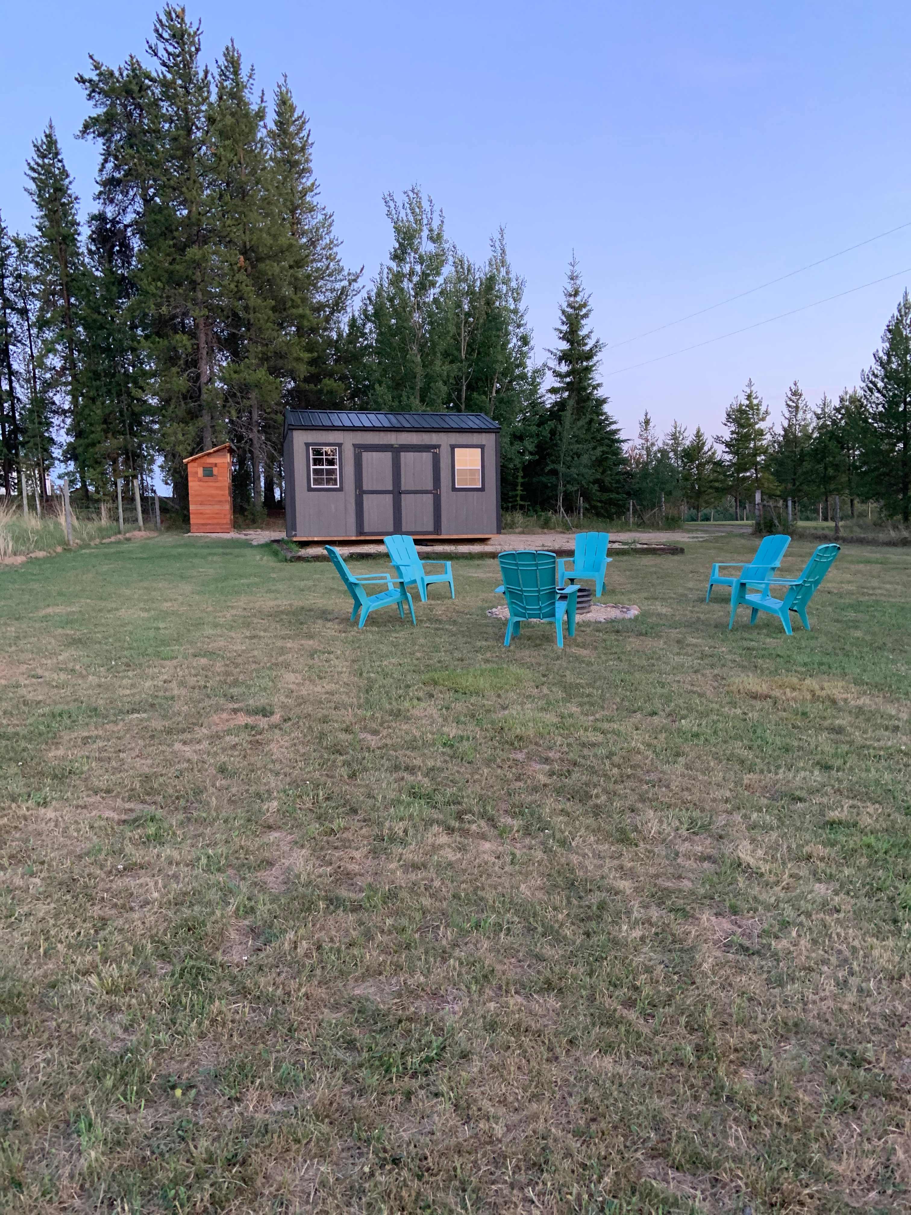 South facing view of campsite; gravel parking pad behind the cabin.  RV or tents welcome anywhere on the grass.  Behind the tree line with plenty of privacy; your host house is on the south side of the land.
