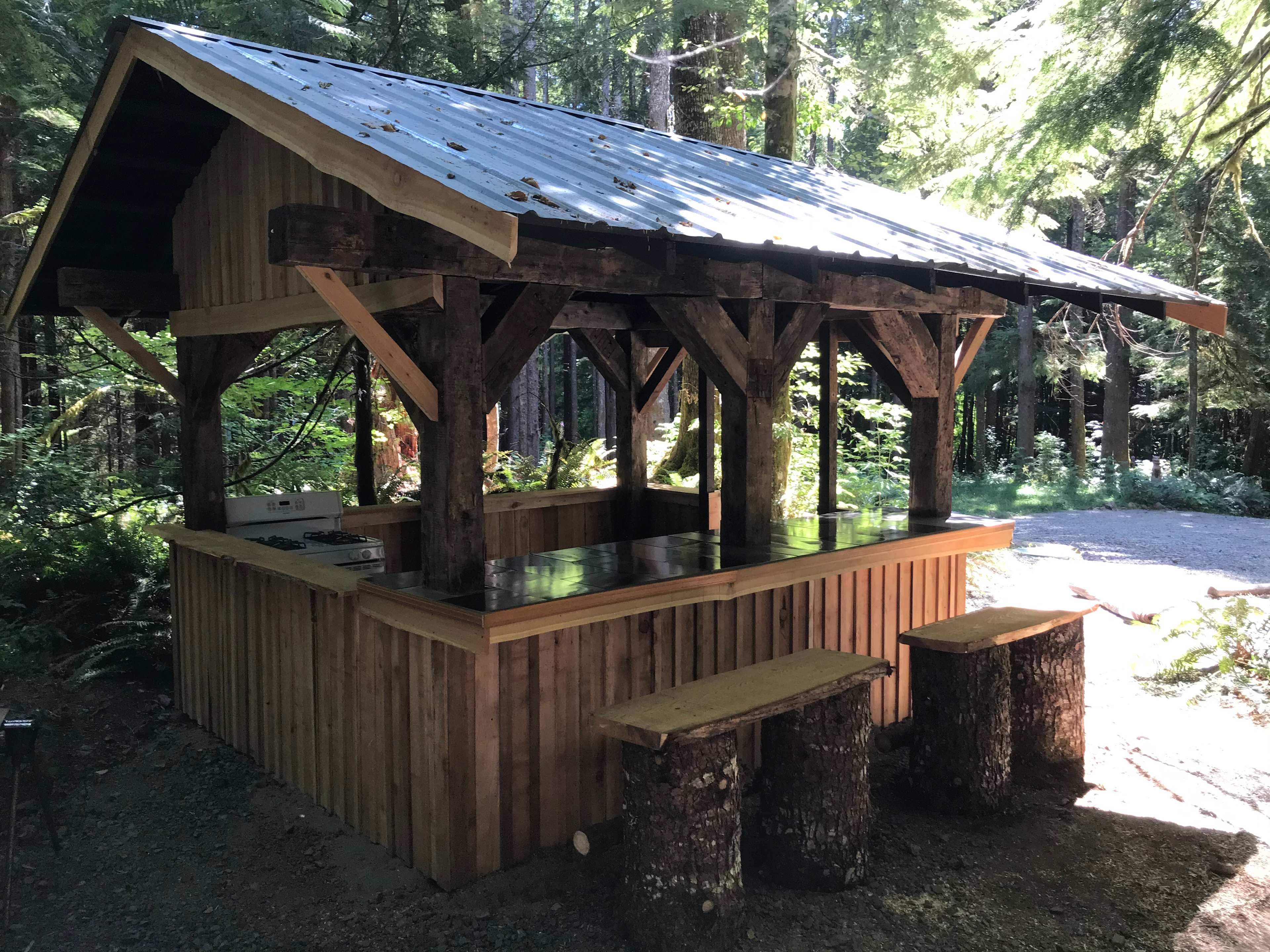 Several covered outdoor kitchens with cooking utensils provided 