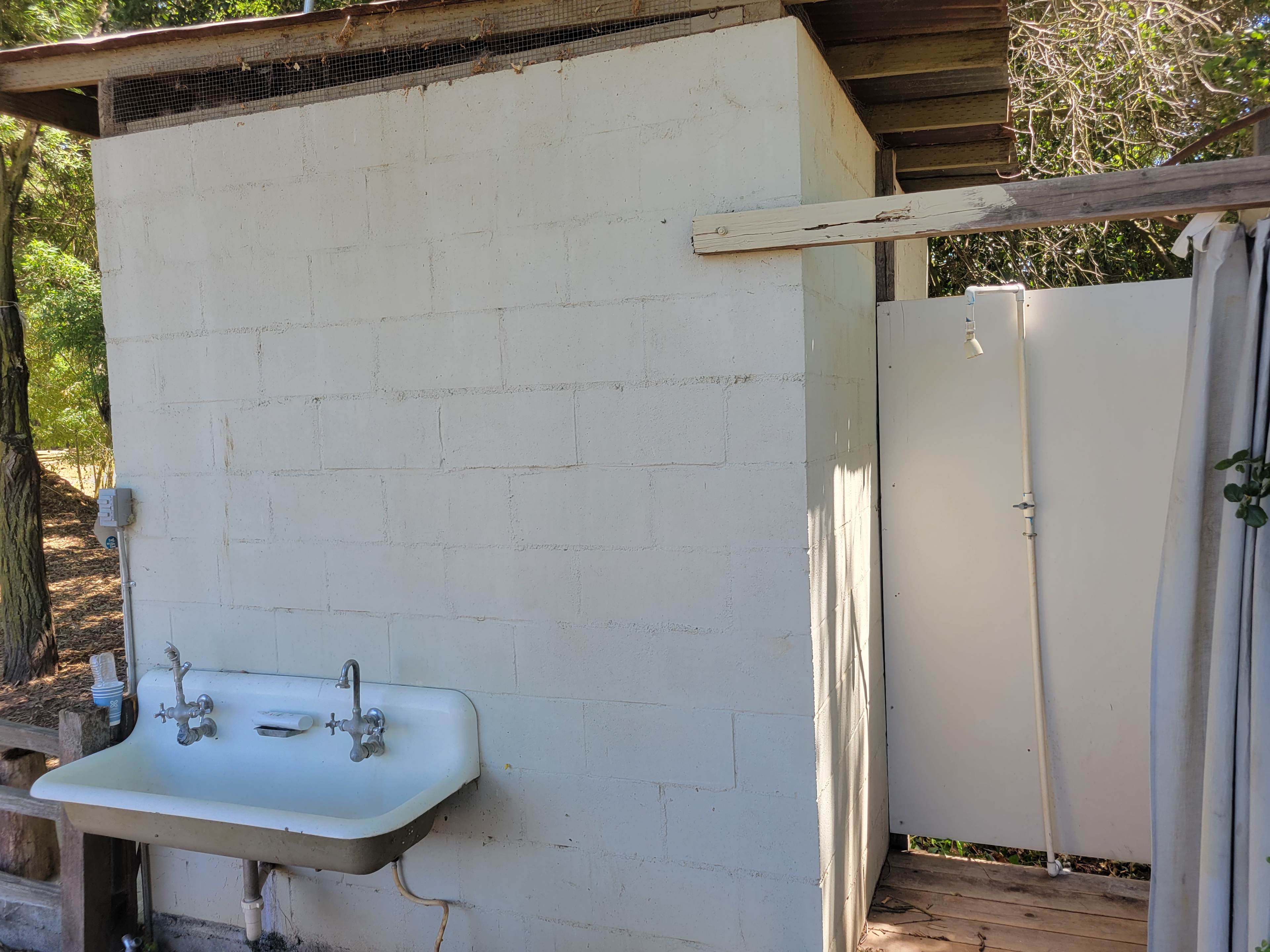 Sink and shower next to bathrooms. Flush toilets. NO HOT WATER! But if the weather is warm it is refreshing if you are adventurous. 