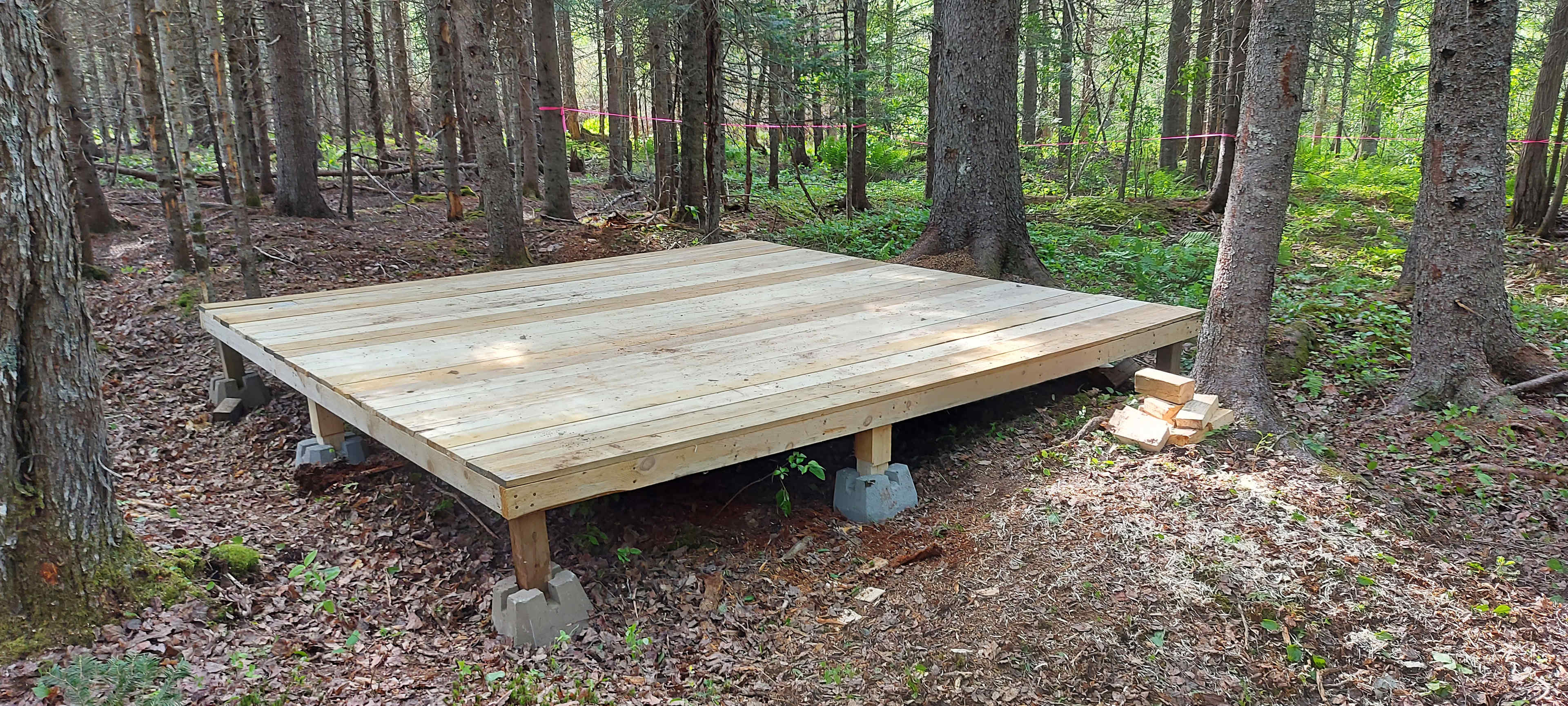 12x12 wooden platform with metal loops on a 4 corners for tie down points . Please do not nail or peg to the platform 