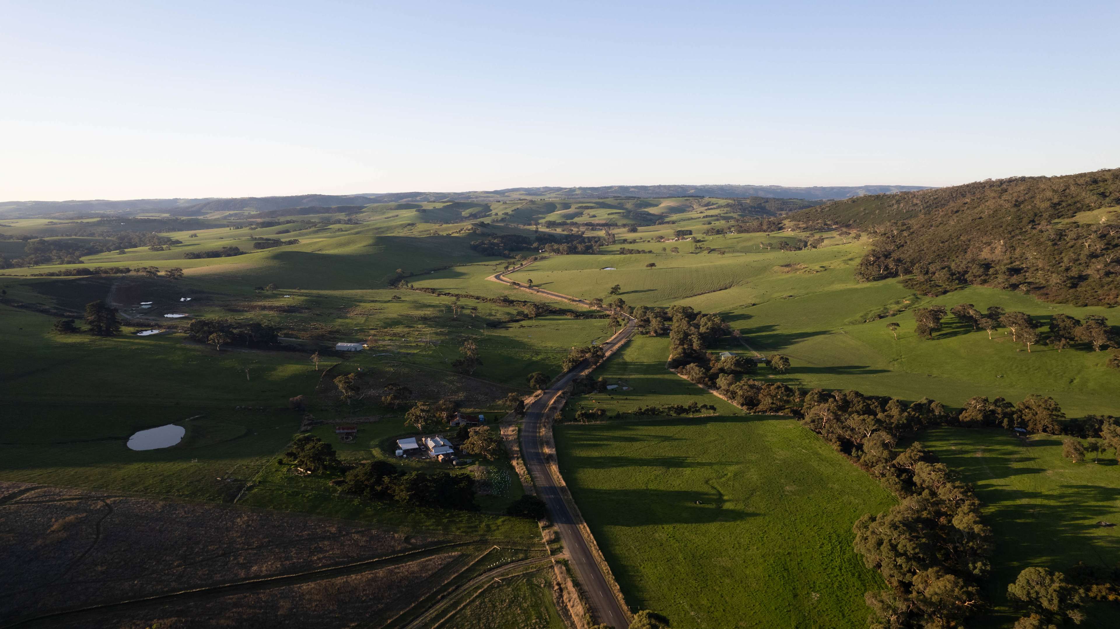 Aerial view of road towards campsite. Surrounded by beautiful hills.