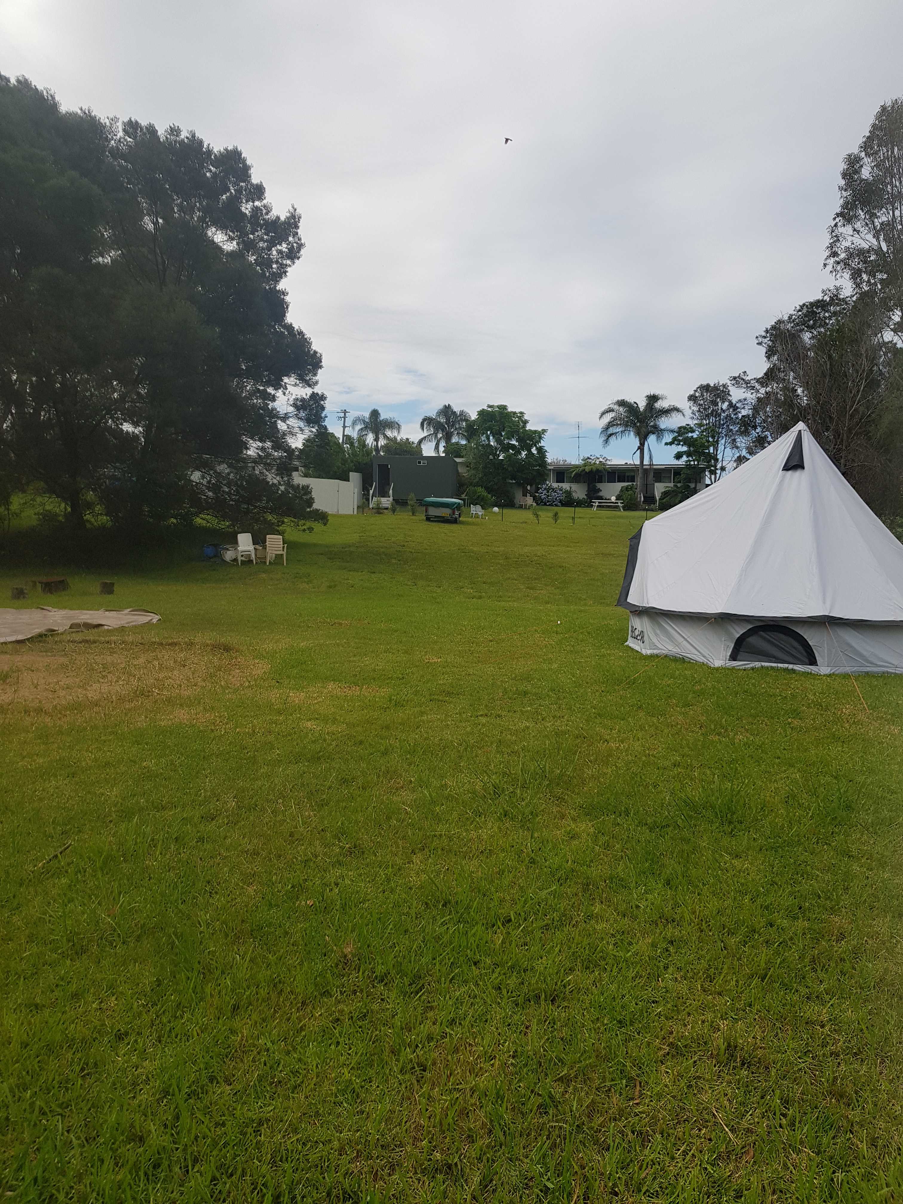 This is the large unpowered site.
Pictured is a 16ft bell tent and to the left you can see a grass mark from a 20 ft bell tent and there is still plenty of room.
The closest camper is up the hill where you can see a camp trailer. 
Behind the camp trailer is the amenities block