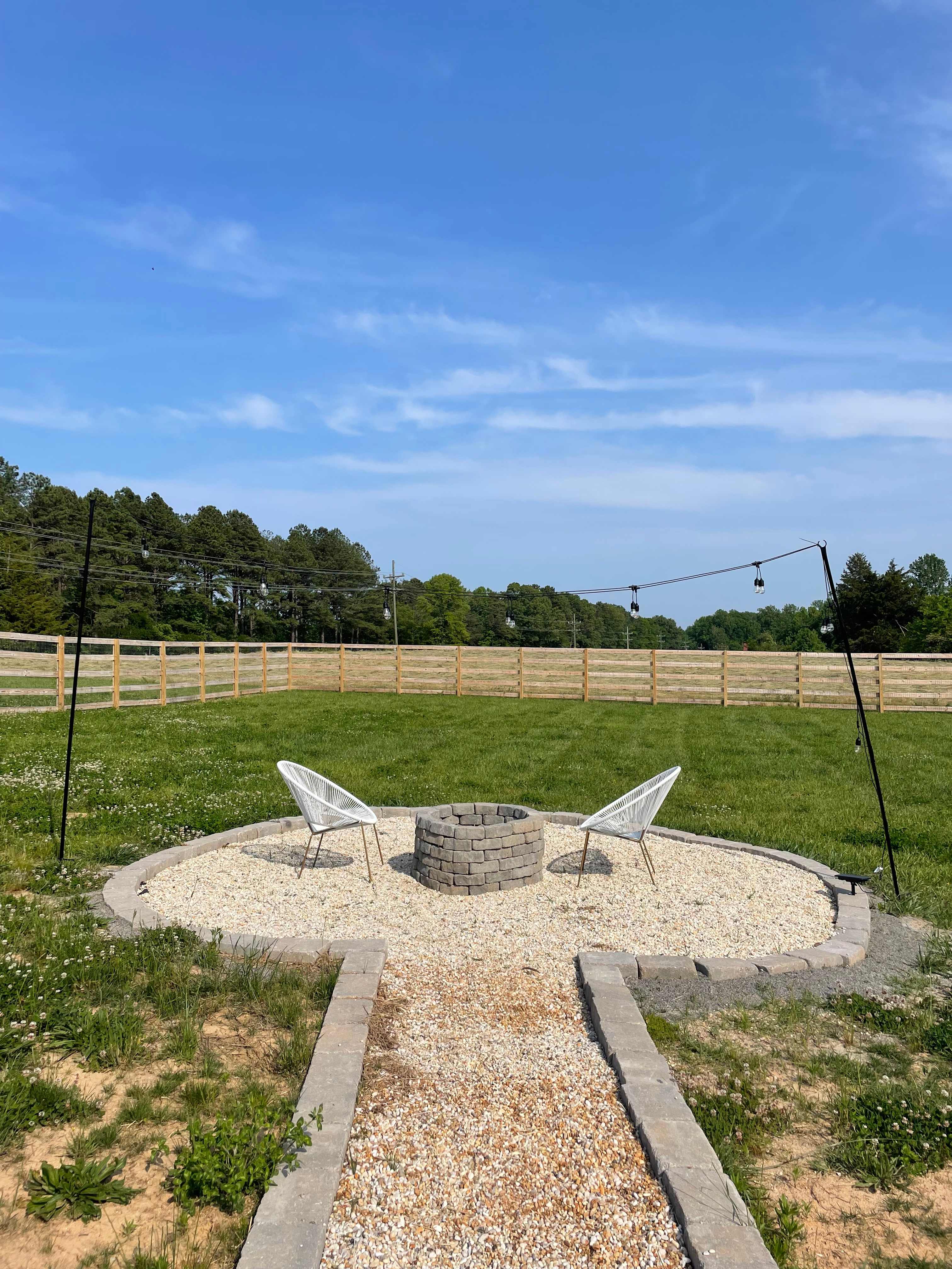 Firepit in the fenced-in yard under the solar lights. Complimentary firewood is available inside the yard near the garden.