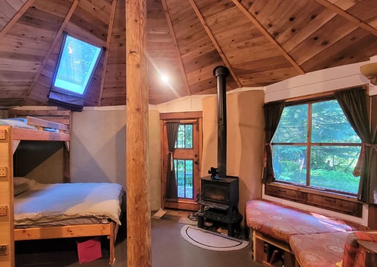 Beds (left) under skylight with curtain.  Bench seat (to right)
