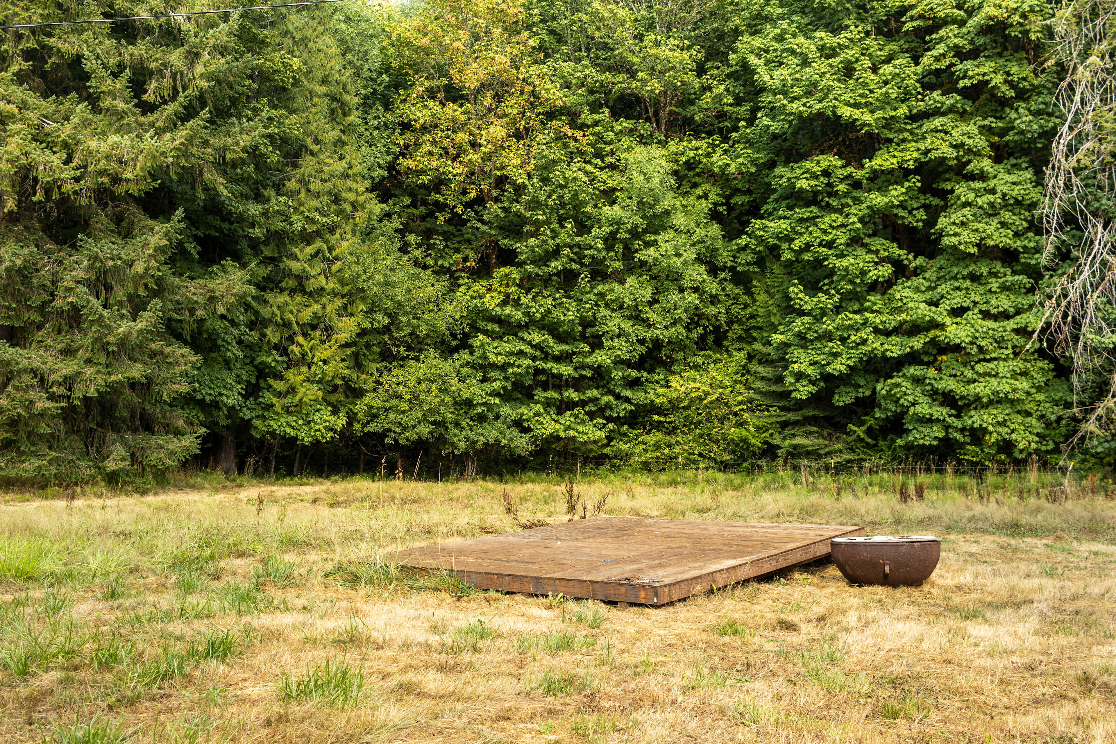 The barnside camp area has a large wooden platform and a fire pit! With plenty of space in the field for multiple tents