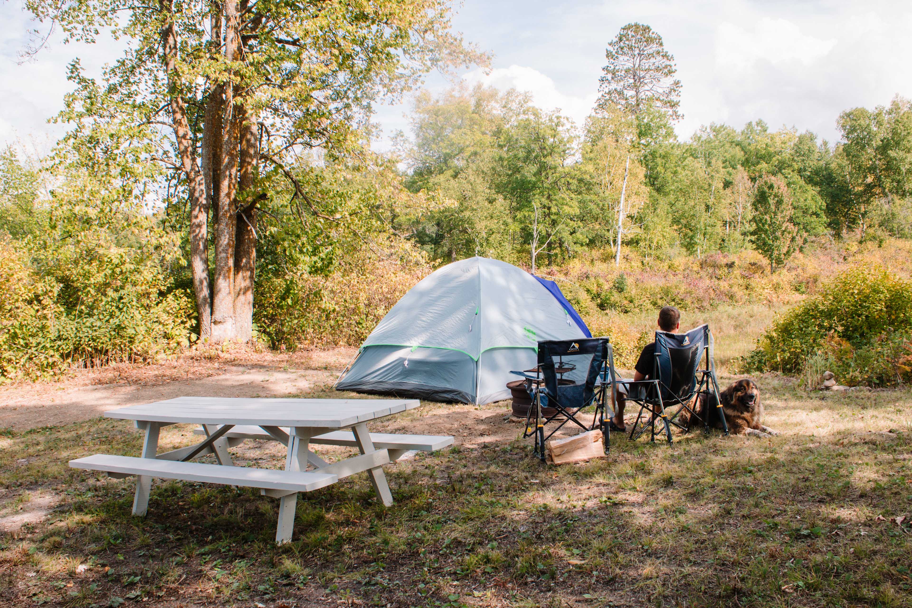 The hosts provide a picnic table, firewood, and cooking grate for the camp fire. 