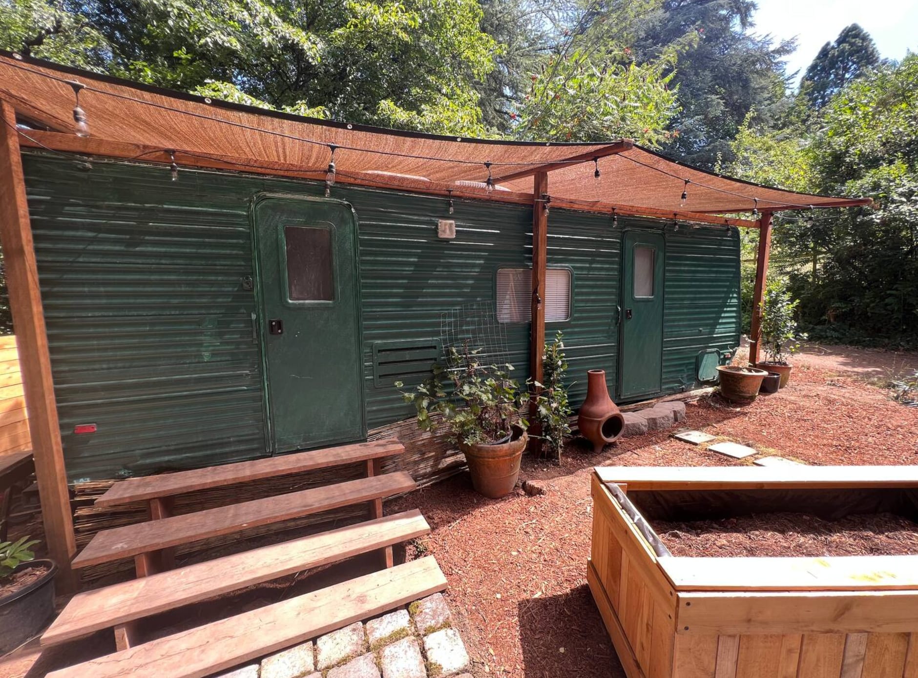 Main road is to the left of this photo, main house is to the right of the photo. The flowerboxes now have tall bamboo and the sunshade awning has been upgraded to green corrugated roofing! We're always improving between guests (new pics soon)