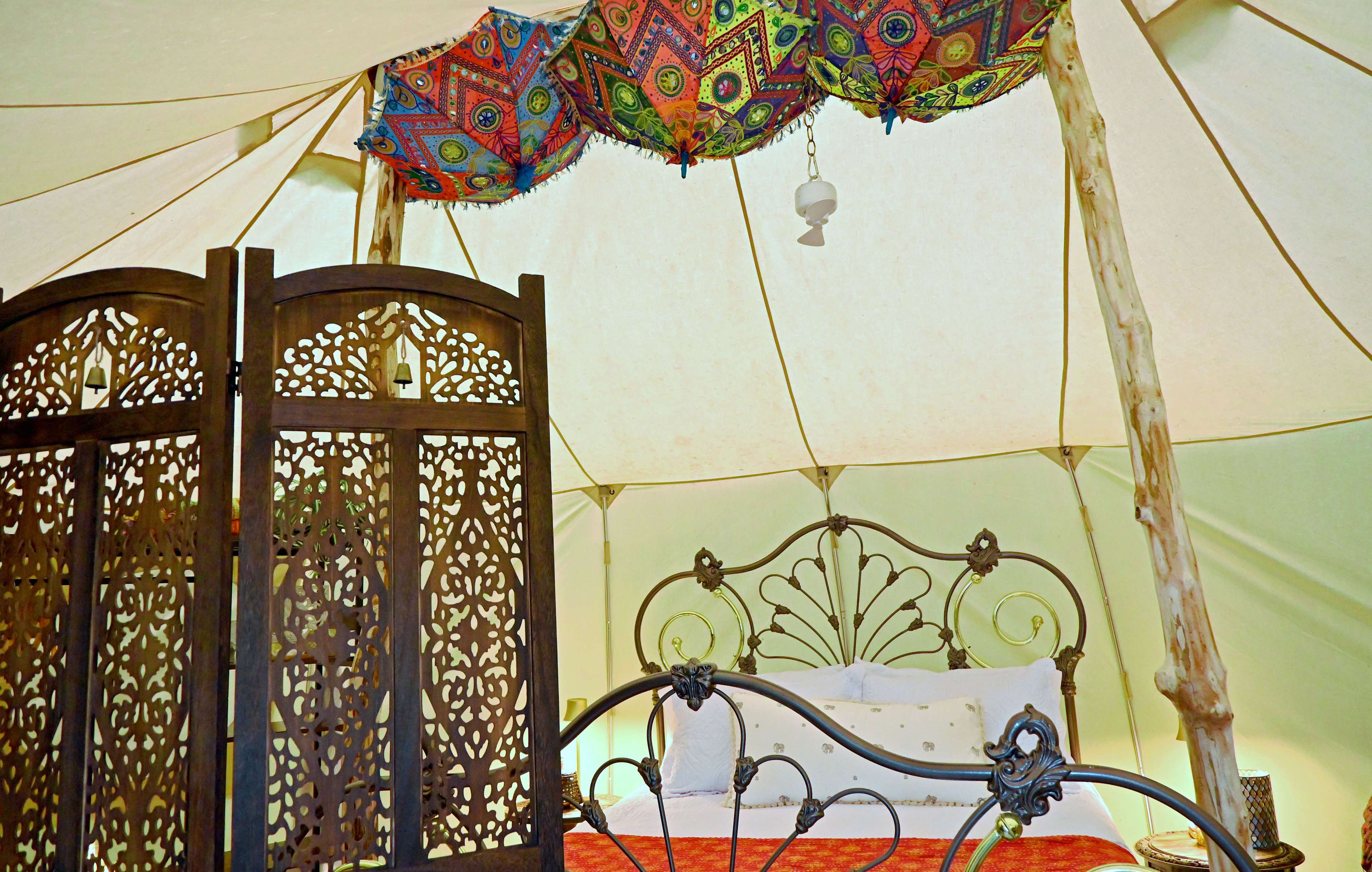 Inside the Bombay Belle cottage's 5'9" walls and under its 8'6" ceiling, you can really stretch out and spread your wings. The intricately scrolled queen-size bronze bed is the centerpiece of your suite.