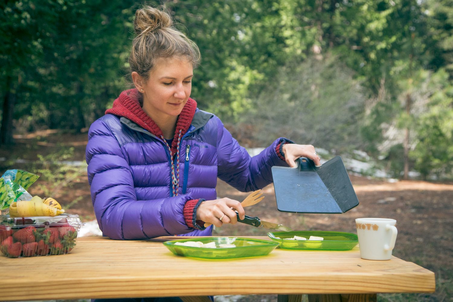 Cutting up some fruit at the picnic table for breakfast bowls.