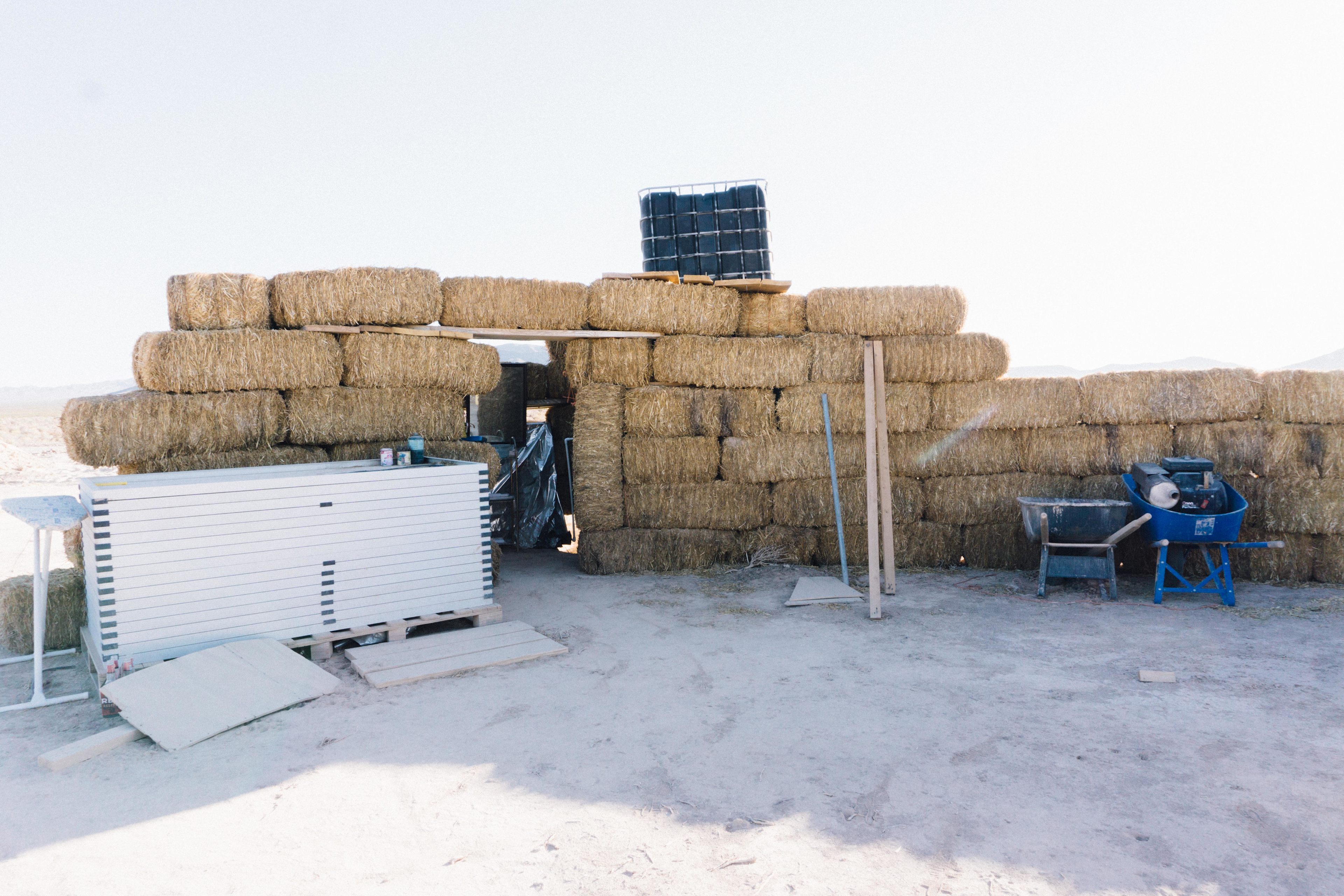 The bathroom is located inside the stacks of hay. There's a solar-powered shower and toilet (bucket with shavings).