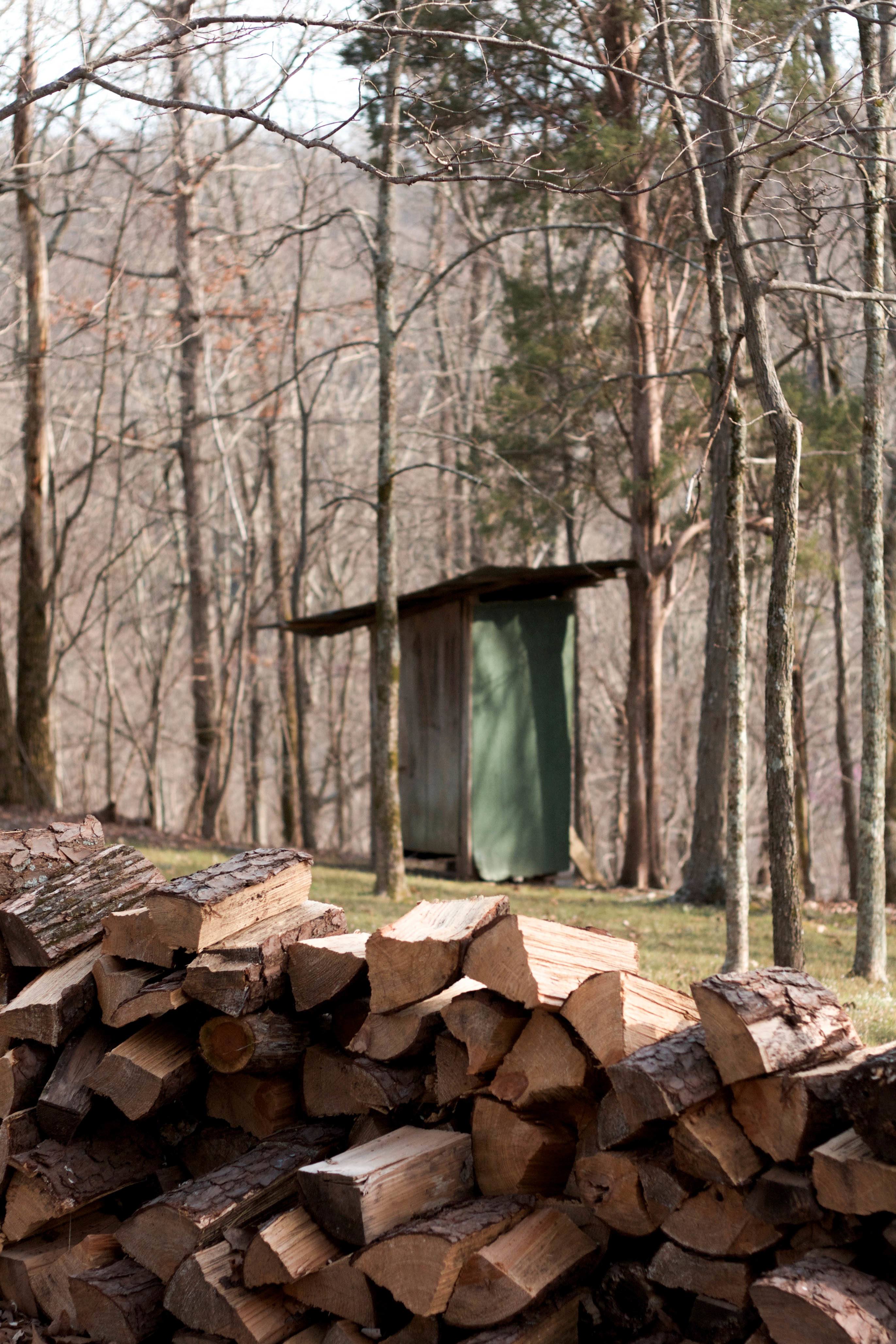 Firewood with outhouse nearby