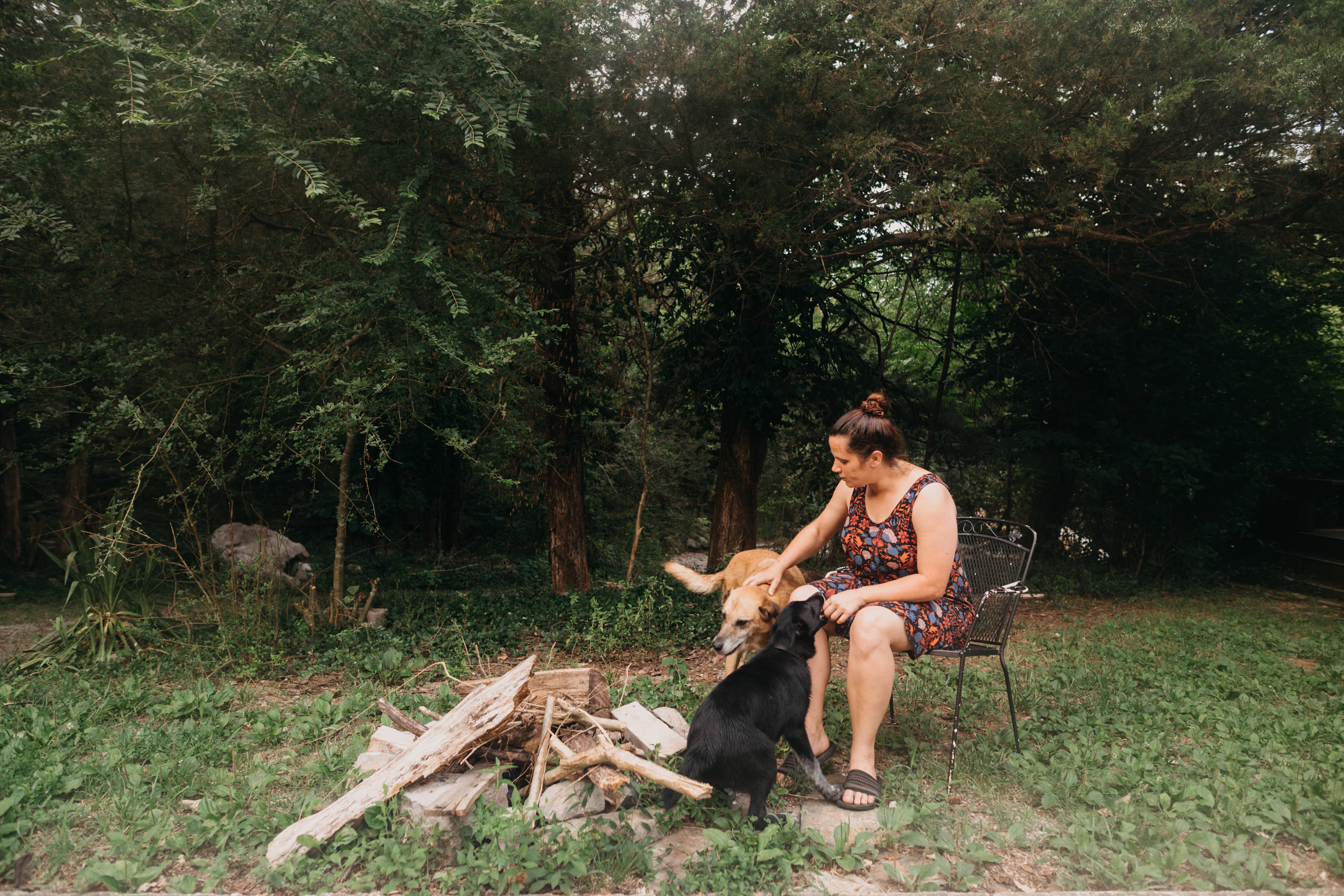 Nicole and some of her dogs sitting at one of the fire pit locations!