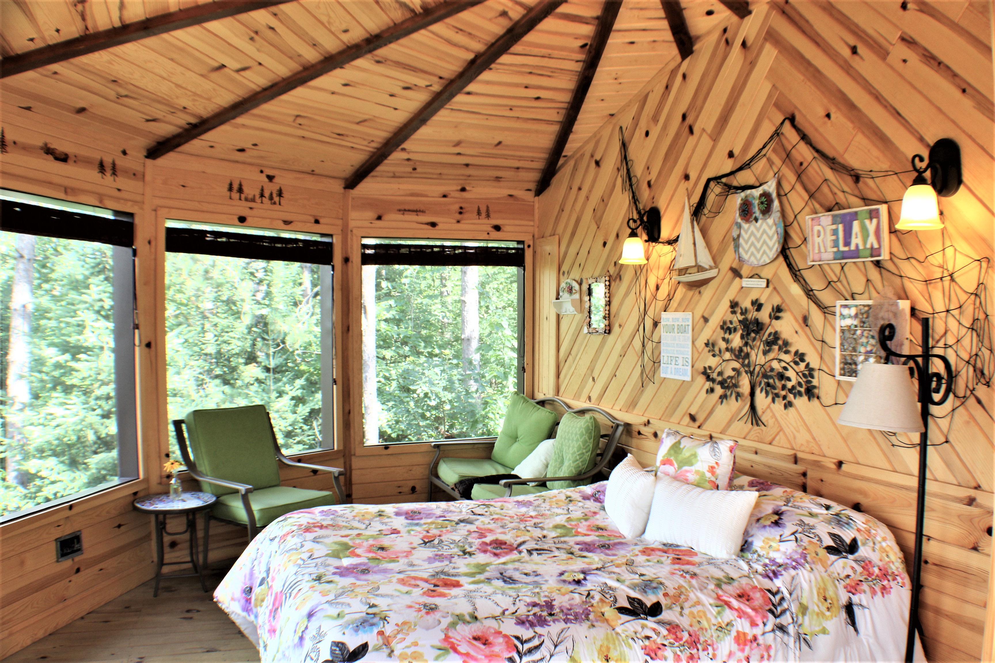 Luxury Queen bed and sitting area in the front of the tree house, sauna is in the back of the tree house.