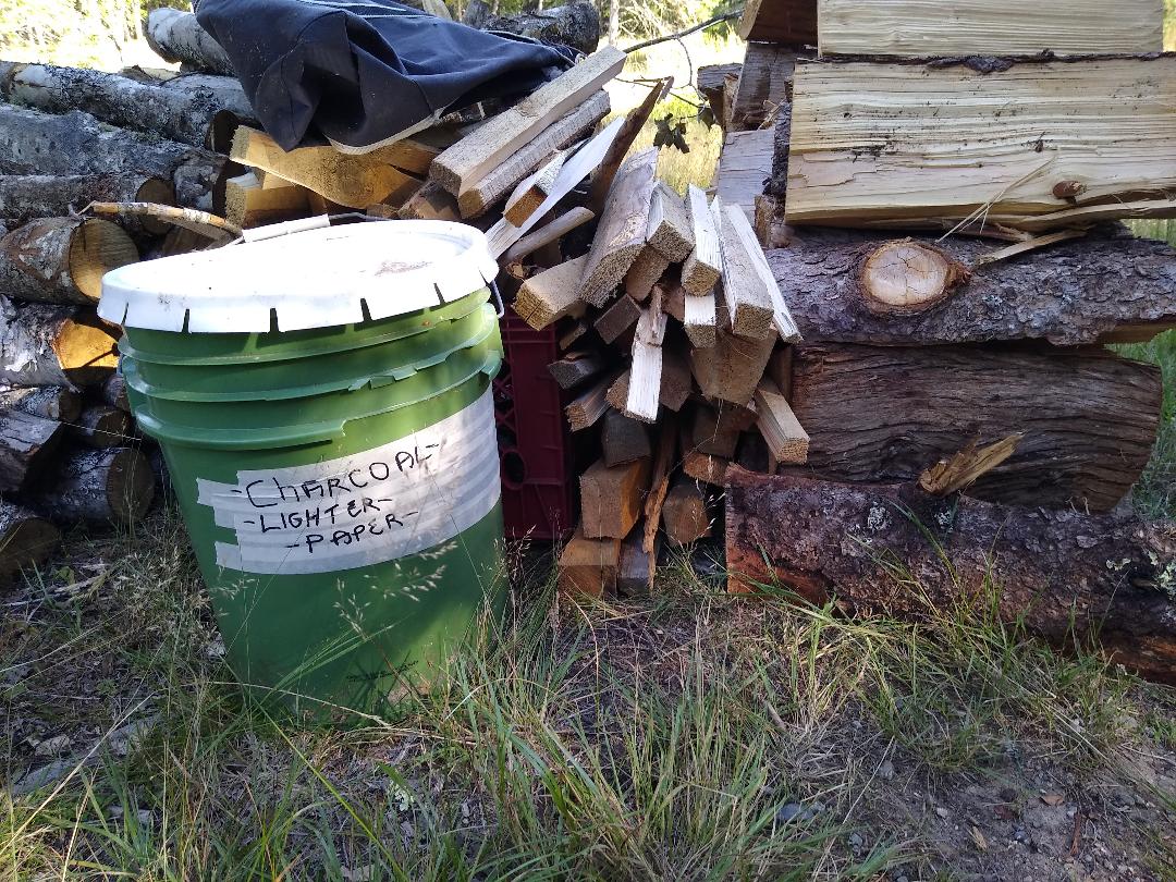 Your fire stuff. Softwood and hardwood, use a mix. Charcoal, paper, and lighter fluid in the bucket if you need it. A log carrier and a tarp to line your car too.