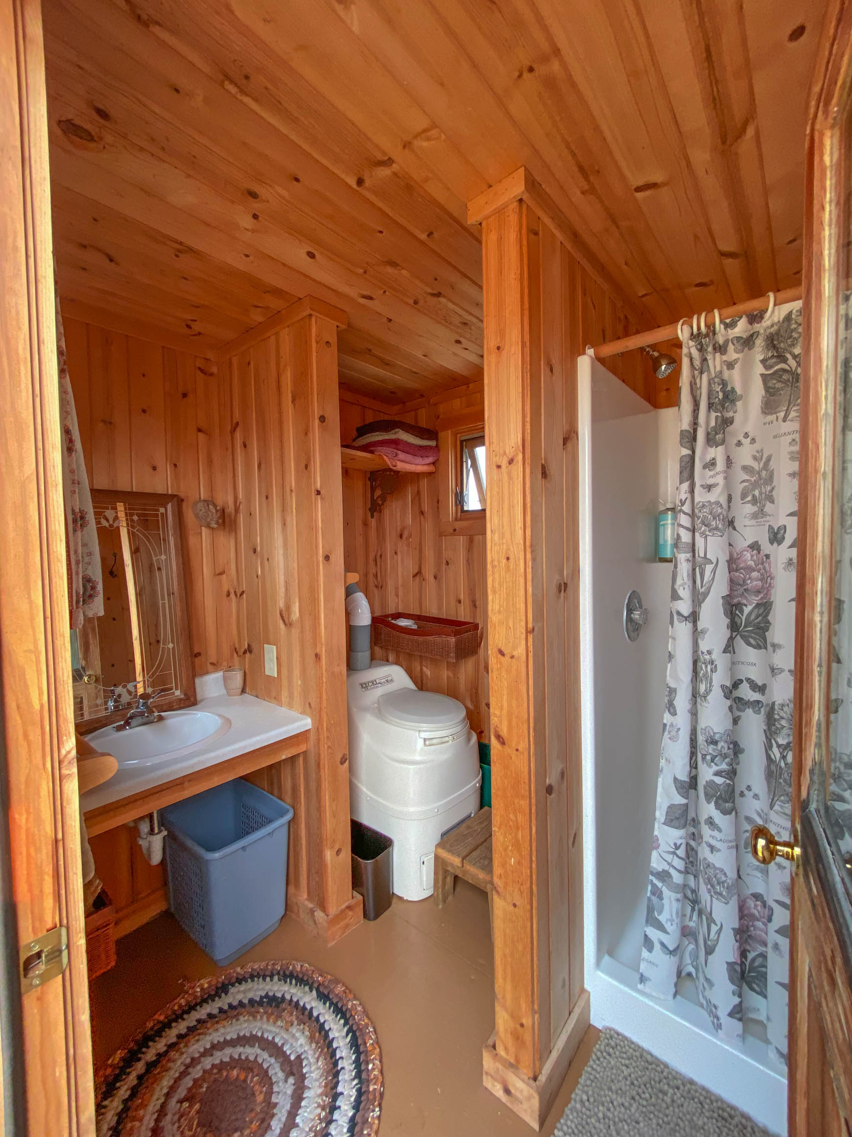 Compact and clean, the bath house has sink and shower.  Porta potty outdoors.