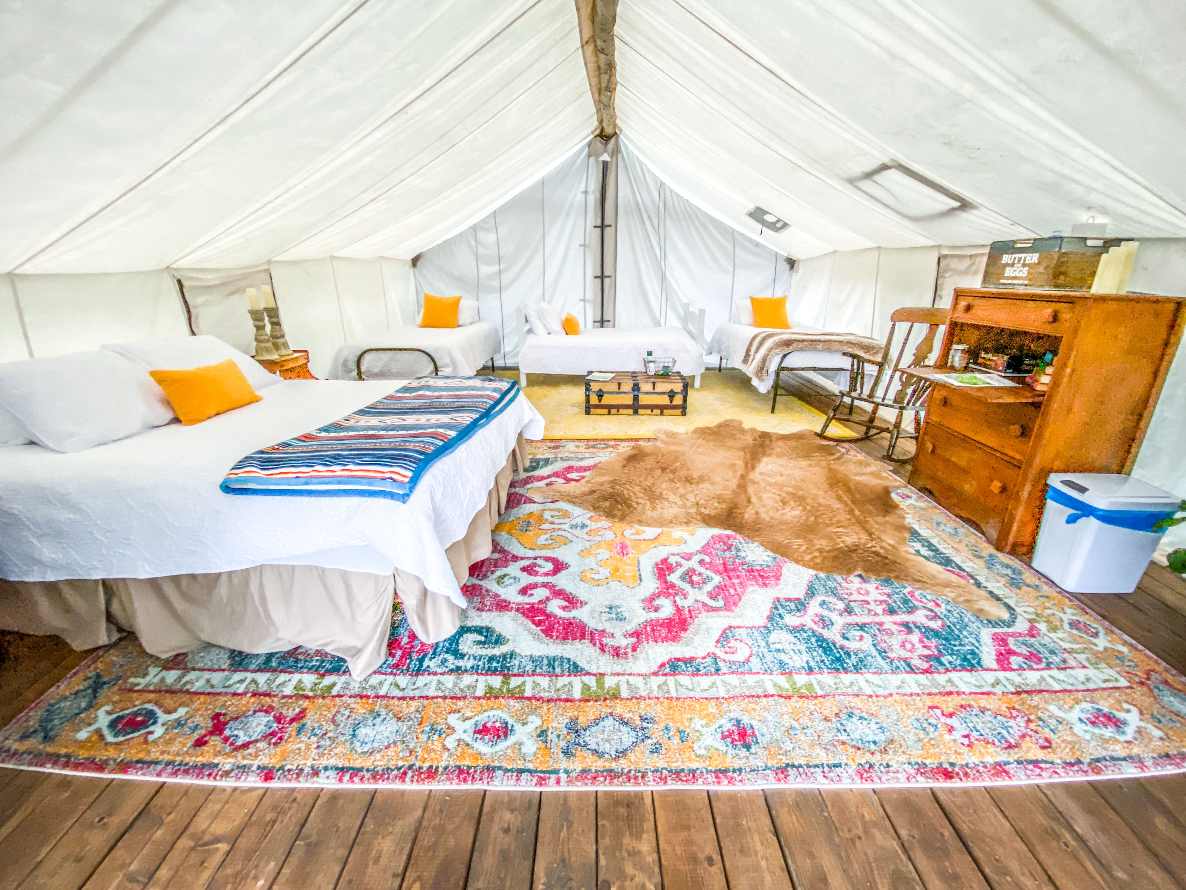 Music Mountain Tent [sleeps 5] outfitted with one queen and three twin beds featuring luxury linens, soft bath towels and battery-operated candles. Bring flashlights for additional lighting.