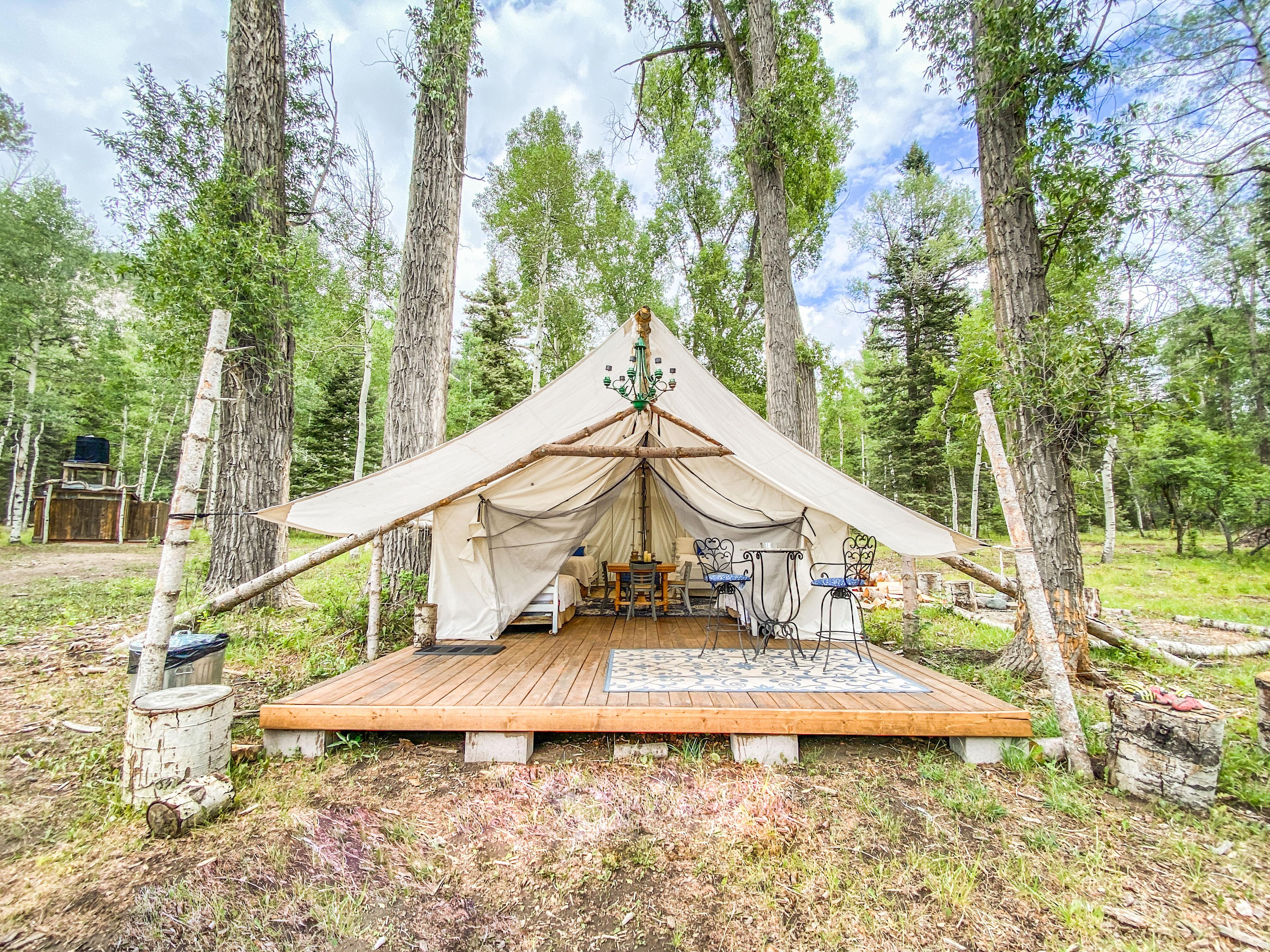 Summit Peak Tent [sleeps 5] outfitted with one queen and three twin beds featuring luxury linens, soft bath towels and battery-operated candles. Bring flashlights for additional lighting.