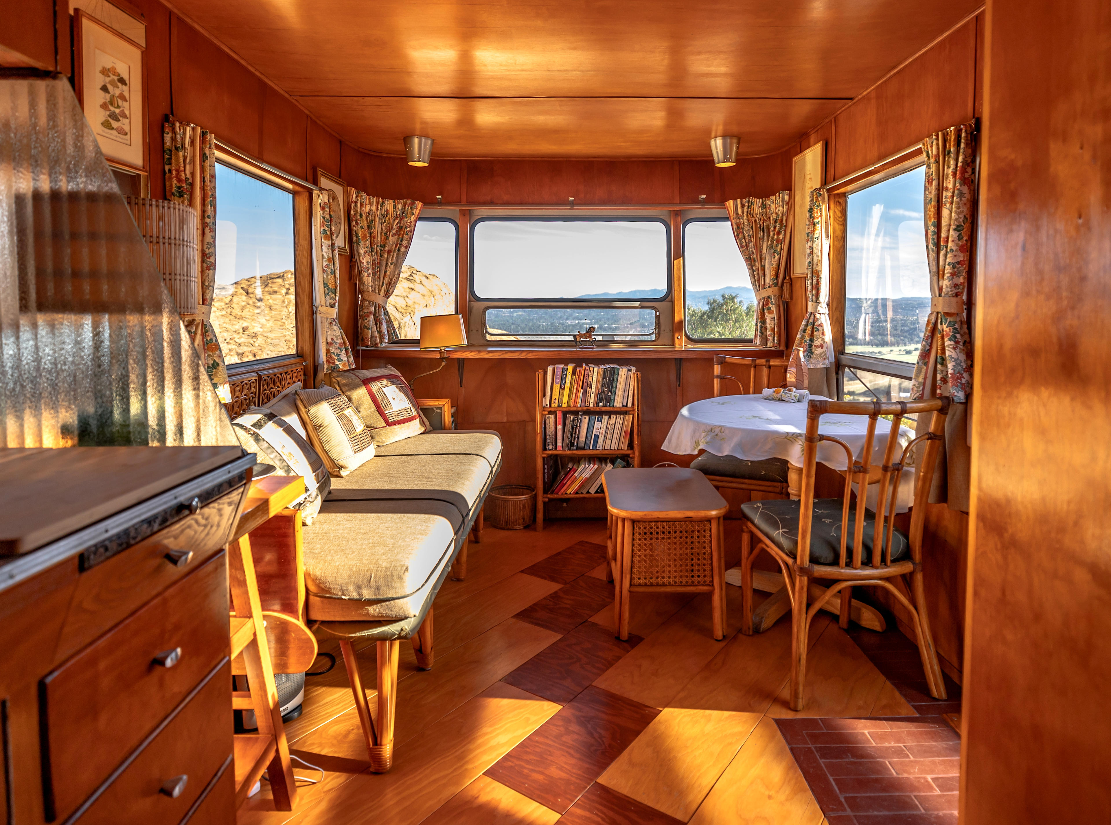 A very comfortable observation lounge offers a dining table and a library. This settee could be used as a sleeping area for a small person.