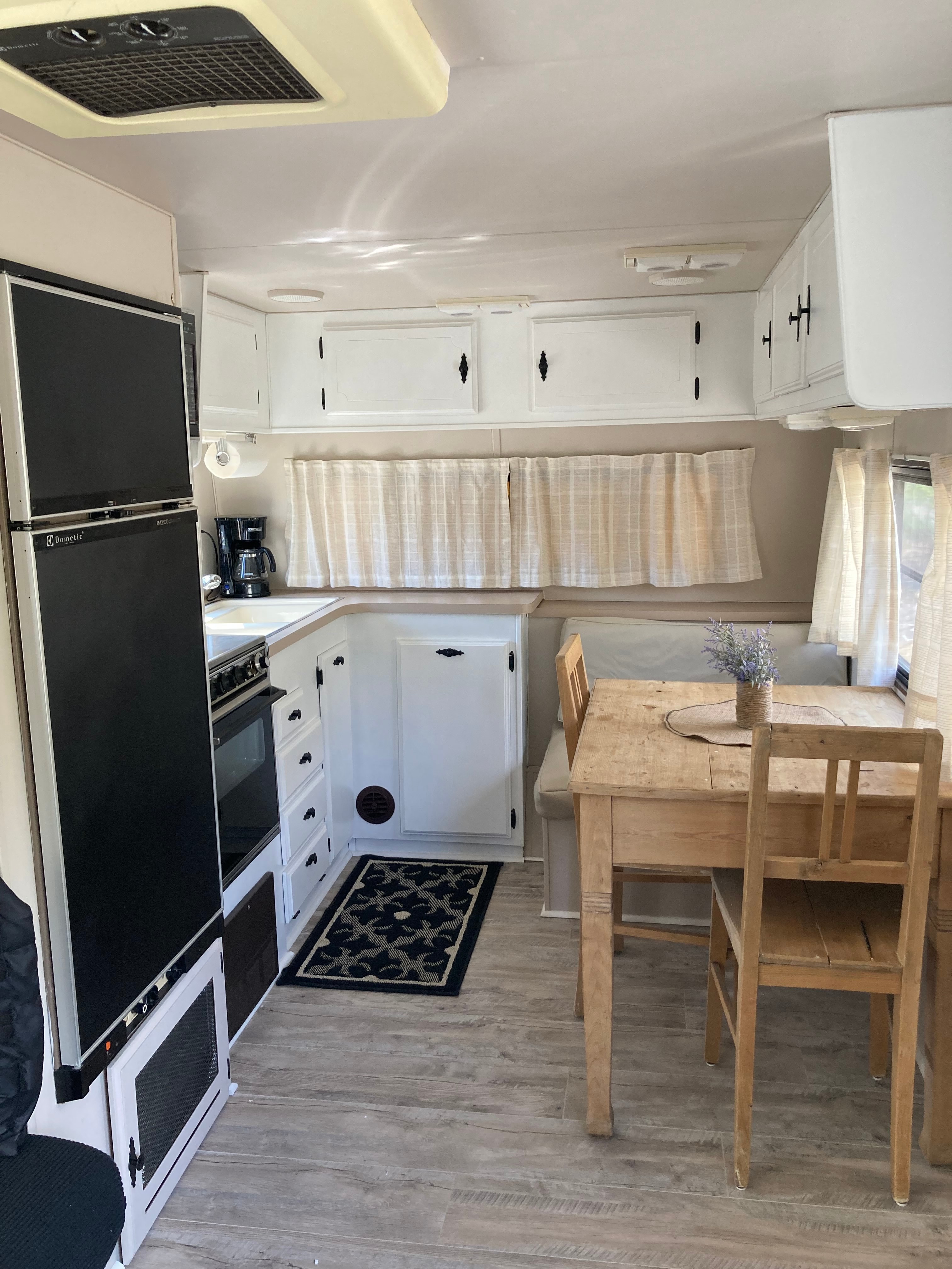 Fridge with  freezer , oven, stove,  microwave, cooking utensils and dishes.