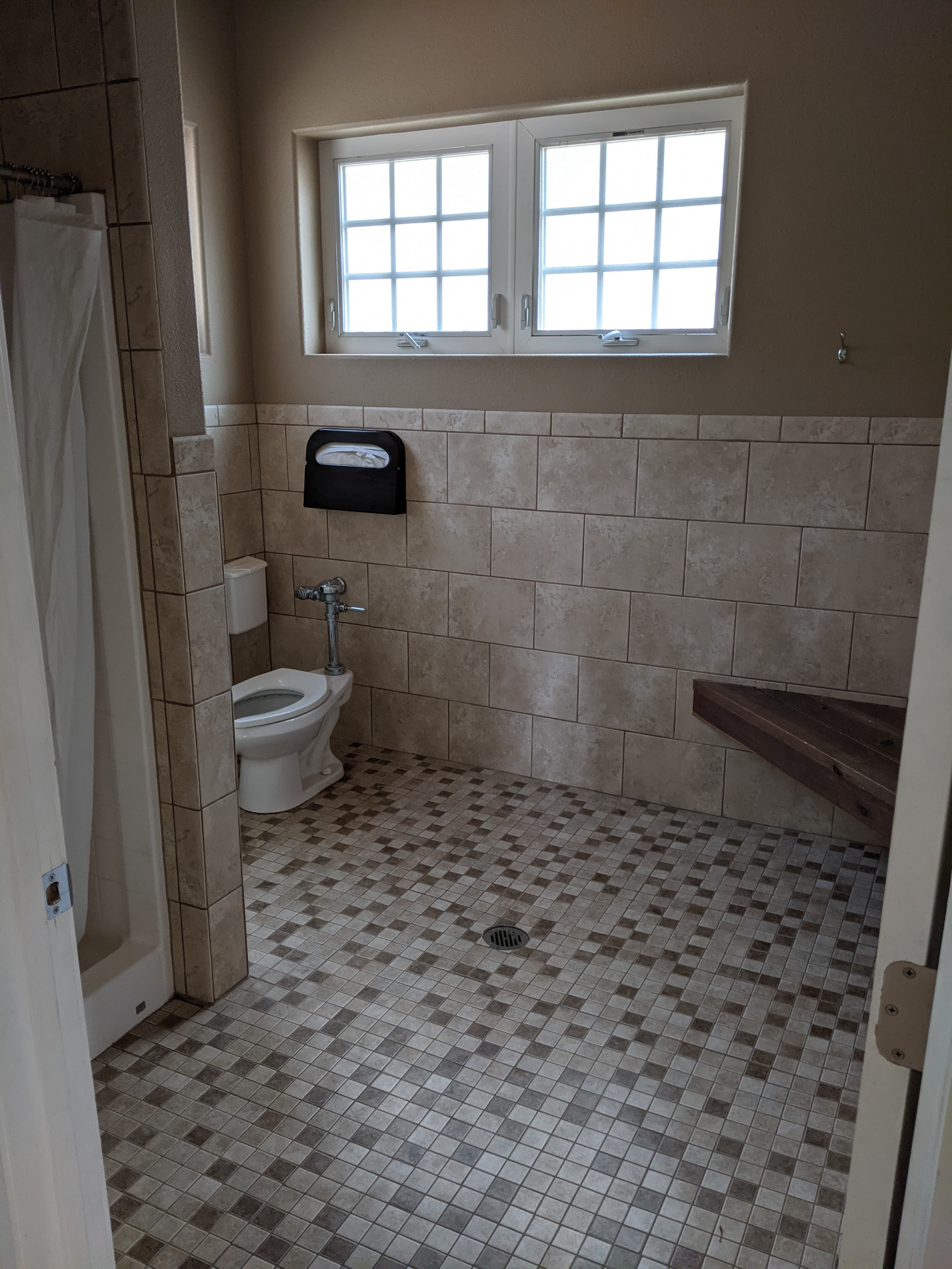 Both shower rooms have showers with hot water, flush toilets, a bench, and numerous hooks for hanging towels and wet clothes.