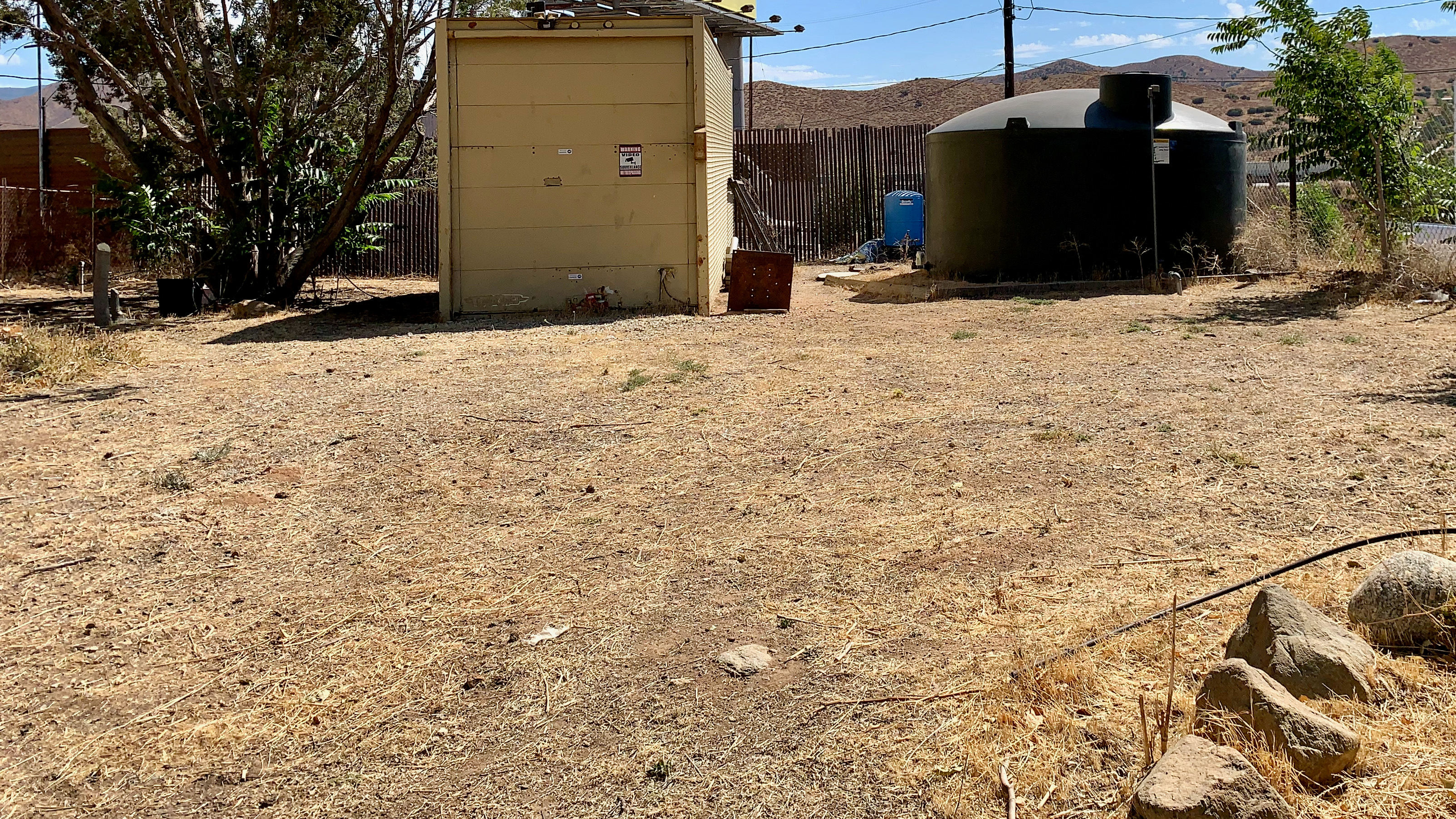 You can park or pitch a tent in this flat area near our water tank and fence.