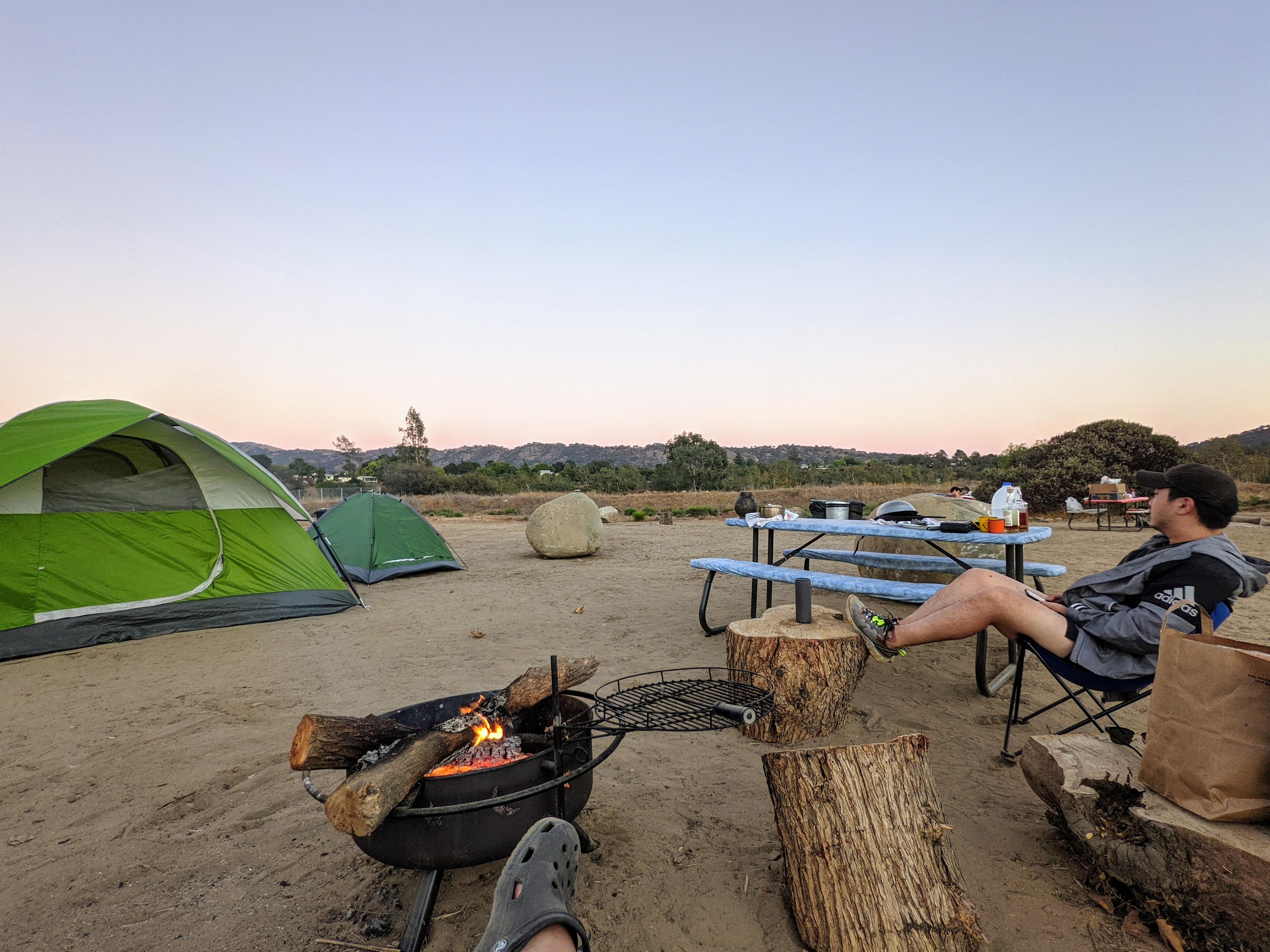 camp set up with tents and fire going.