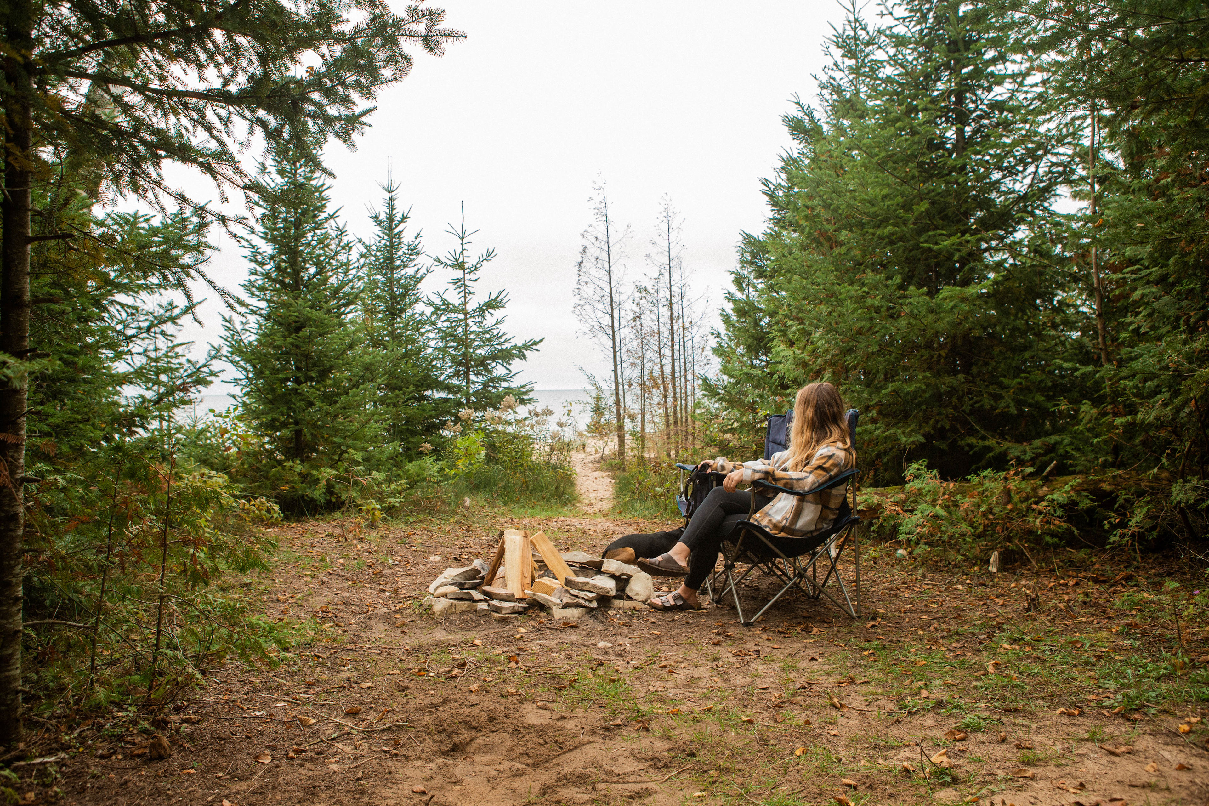 There is a clearing in between the wooded area and the beach that has a firepit and plenty of room for a tent.