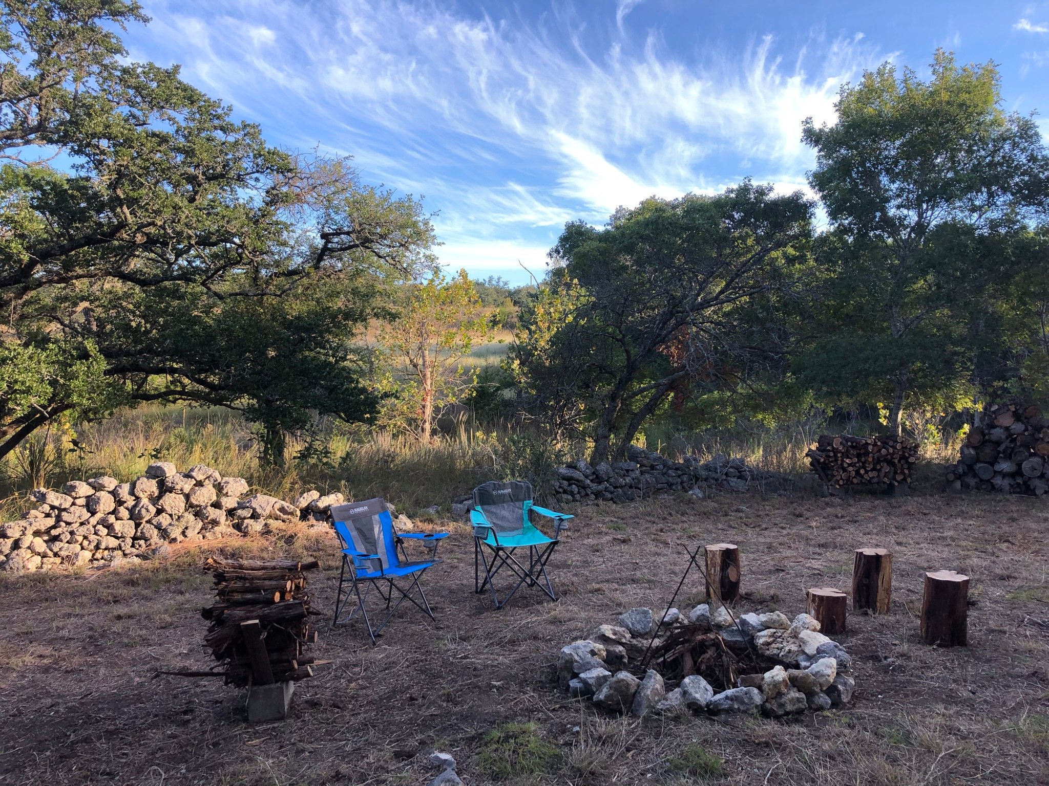 Camp site is next to an old pioneer rock wall fence and in a grove of mature trees 
