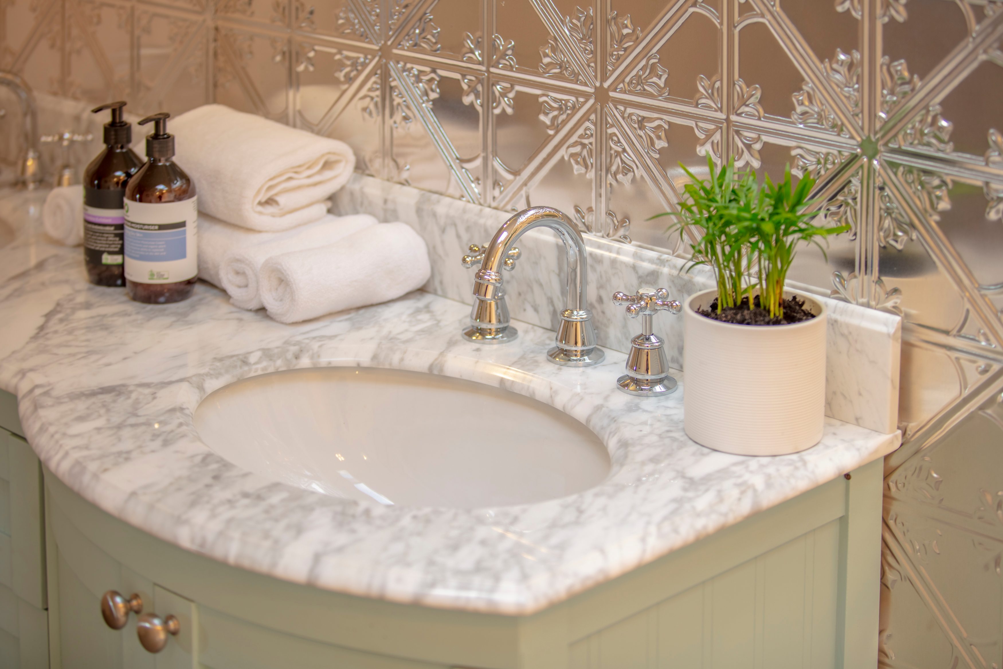 Marble double vanity, pressed metal backsplash, Saba Organics, plush towels and robes