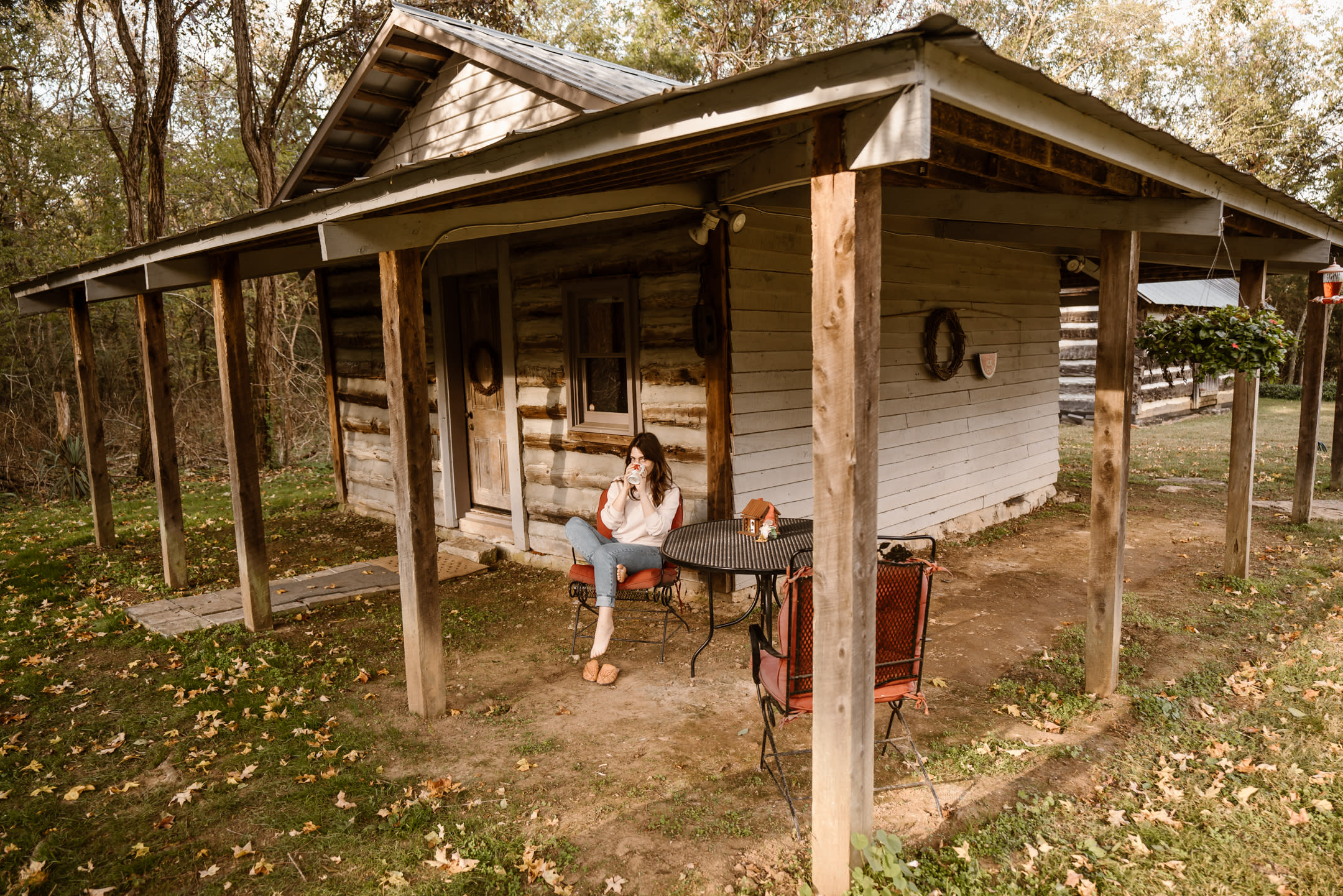 There’s a patio table and chairs set up outside of the cabin.