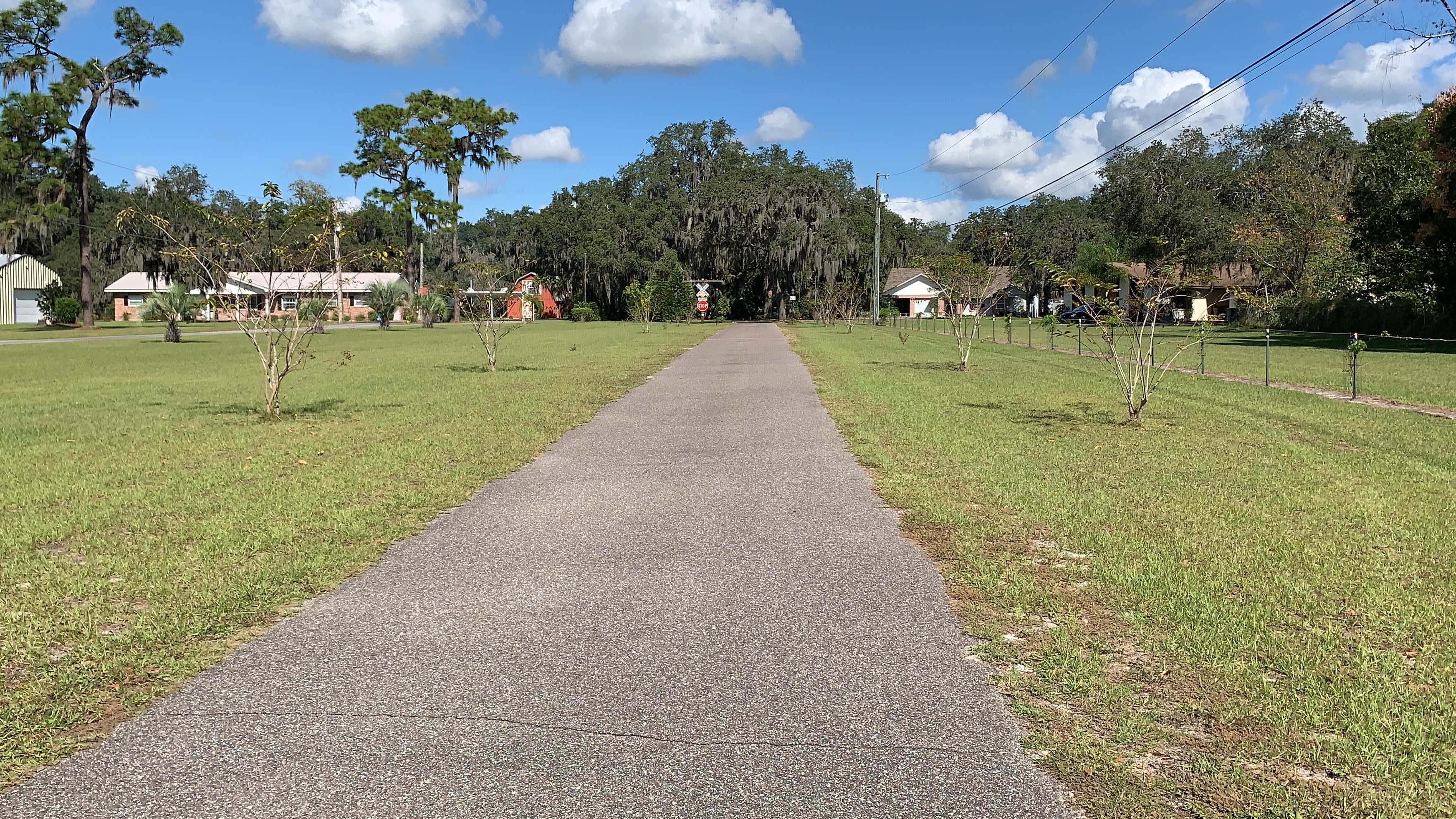 Stop sign by trees will guide in from paved driveway.