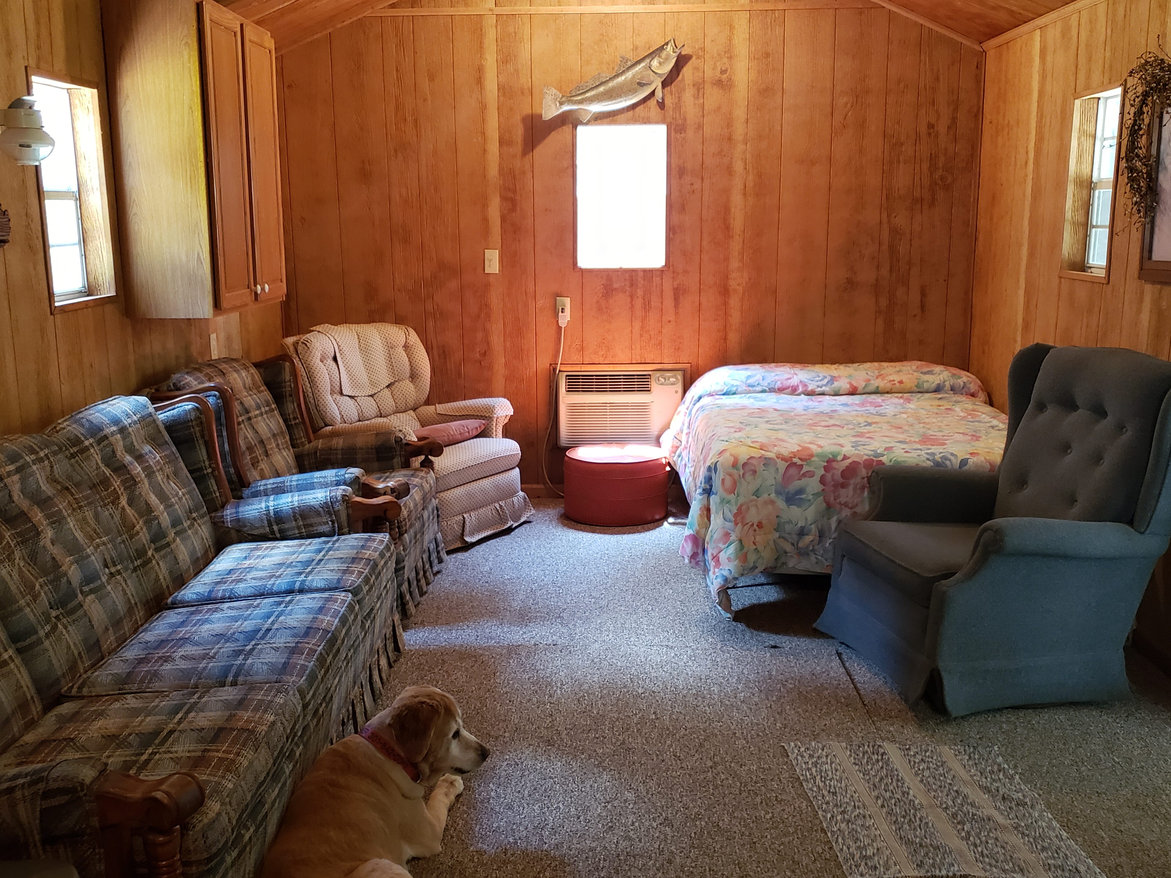Amber Lodge at Glamping Clear Spring Maryland 3-Cabin Campground has 2 double beds and bunkbeds. A TV with VCR and a Smart TV, a couch, chairs.