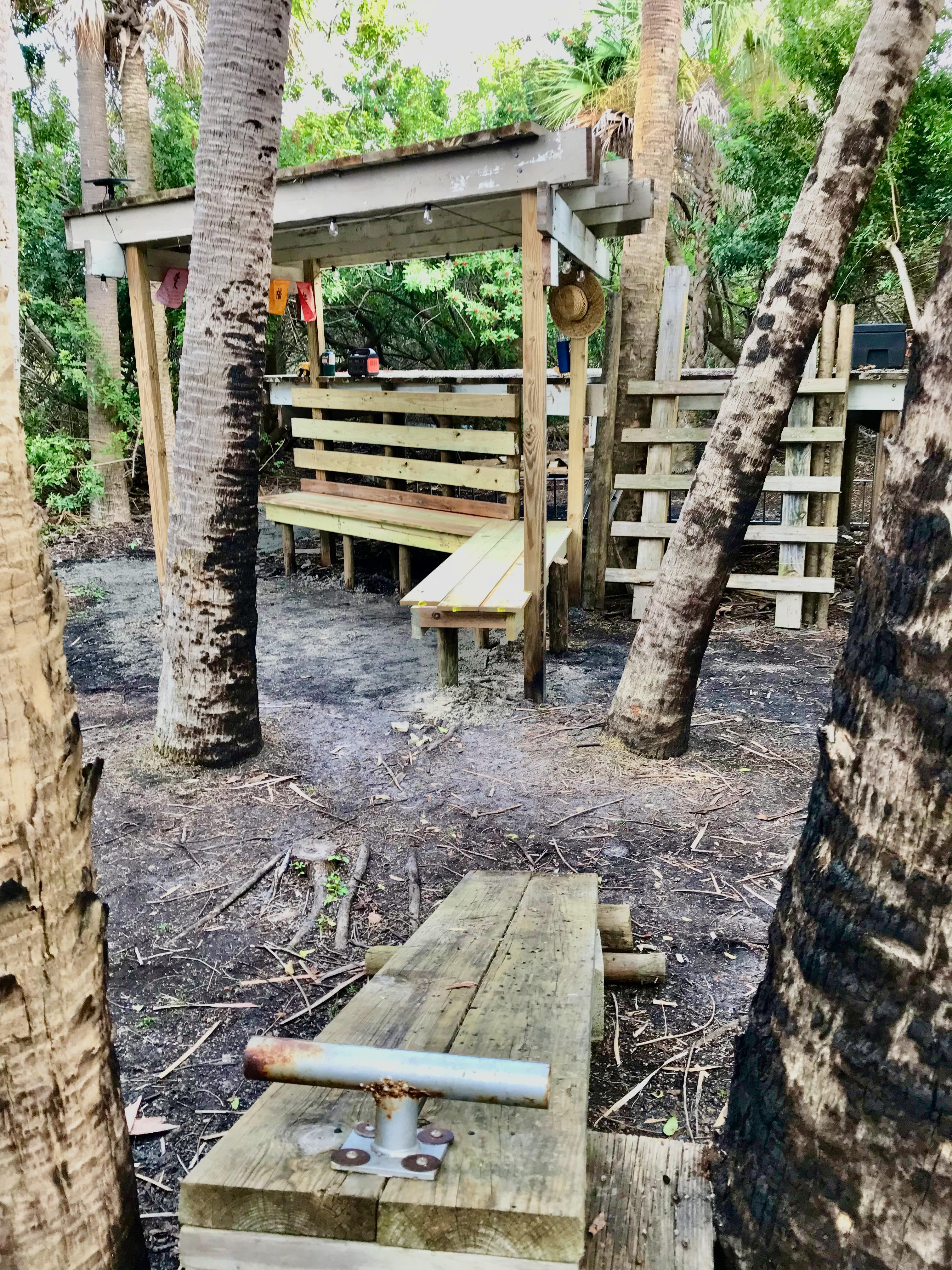 Covers Bench and tent platform with adjacent tree bench and work-out station.