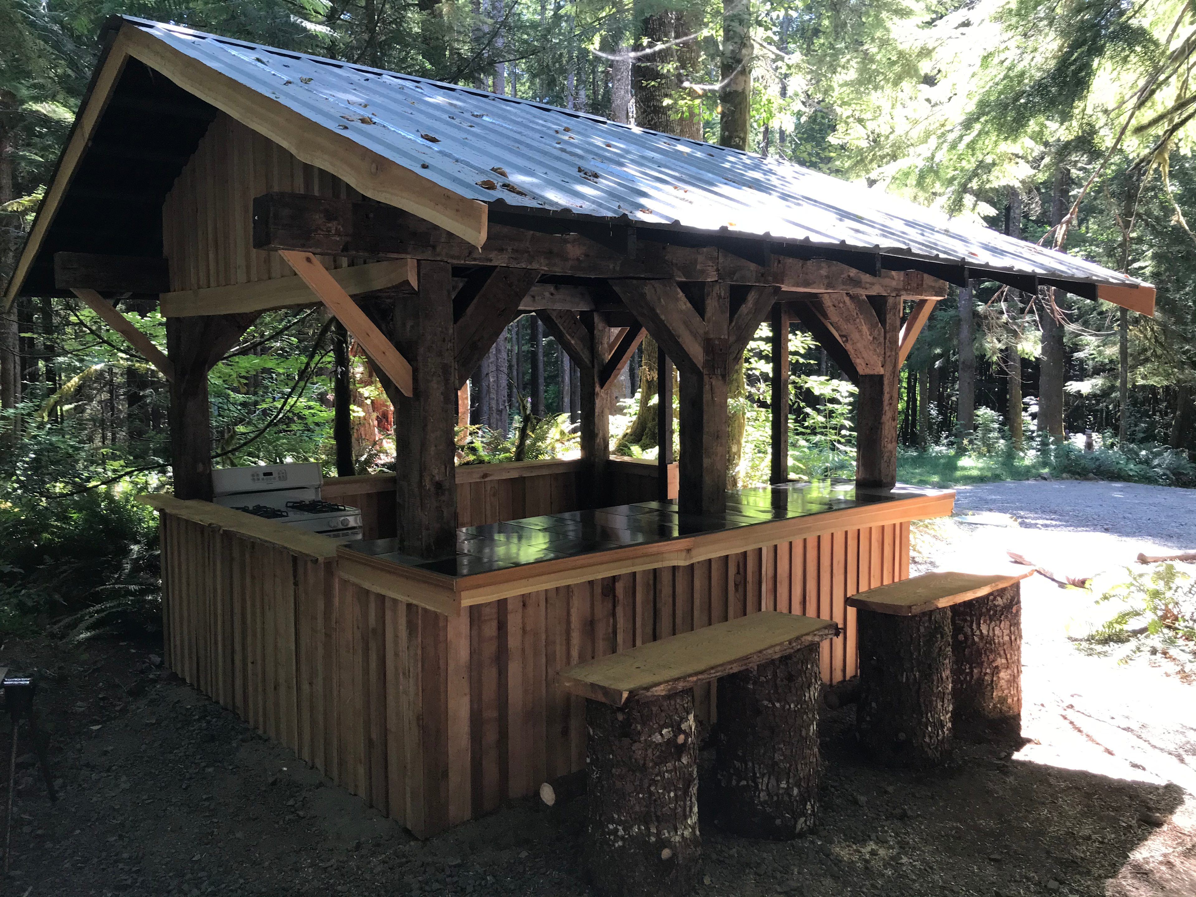 Several covered outdoor kitchens with cooking utensils provided 