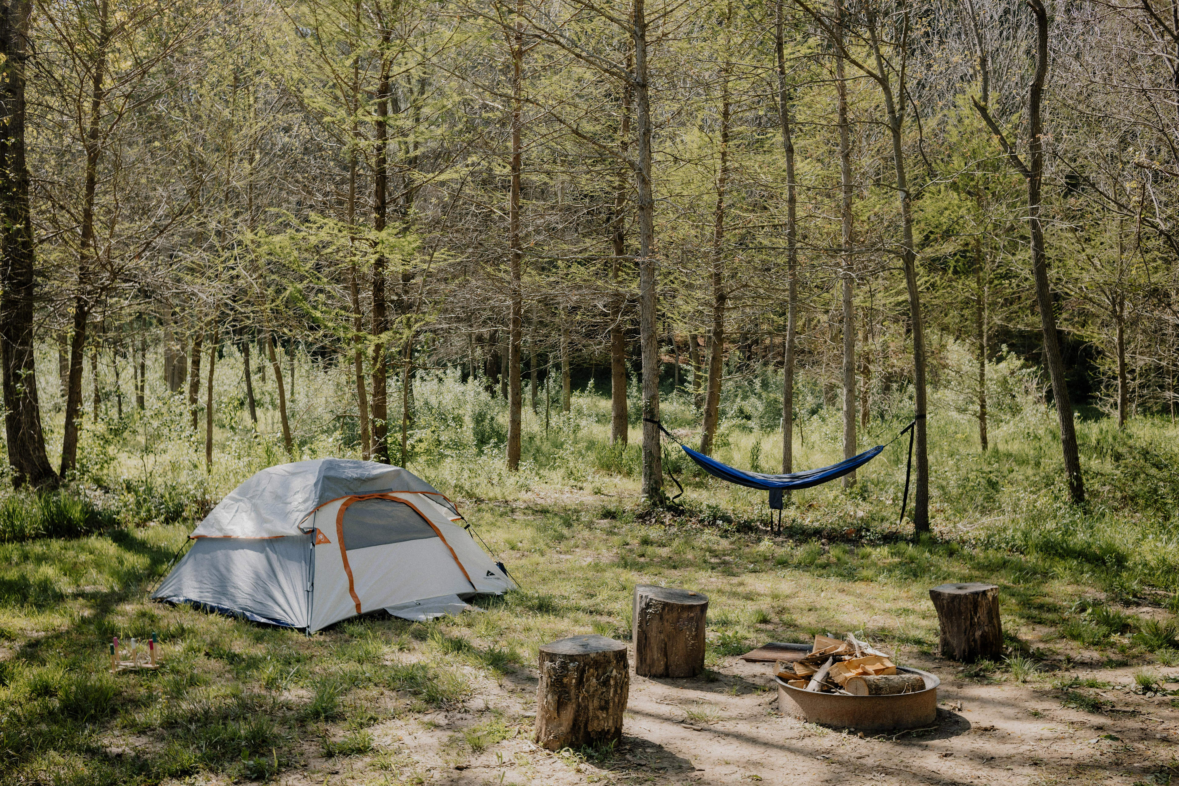 Campsite #4 on top of the hill and equipped with firepit, grill, 3 log chairs, and picnic table. 