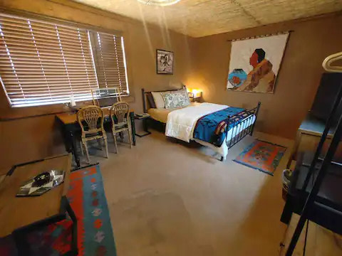 VIew of desk and bedroom. Desk has views when blinds are open.