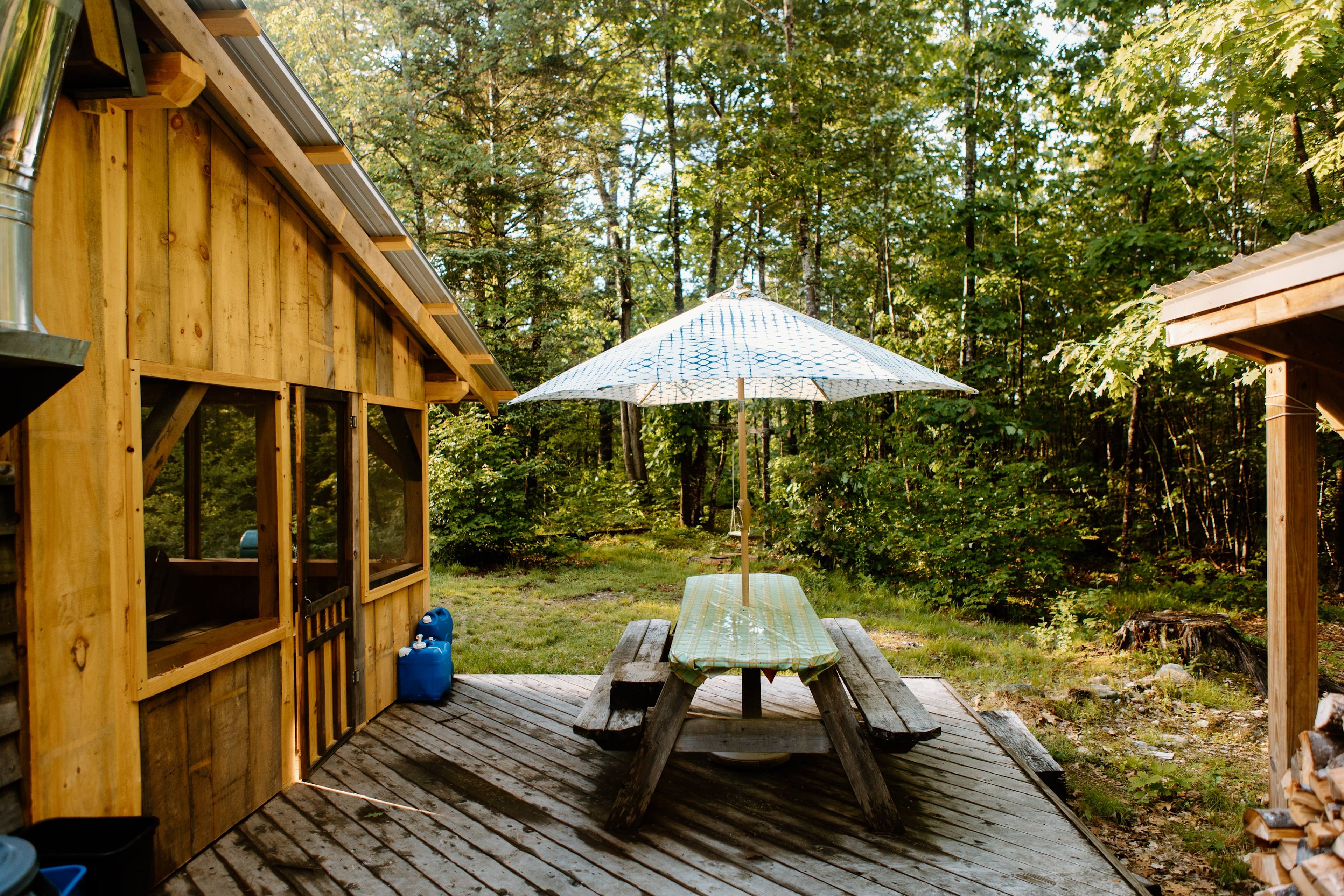 a picnic table on the deck next to the screened in porch 