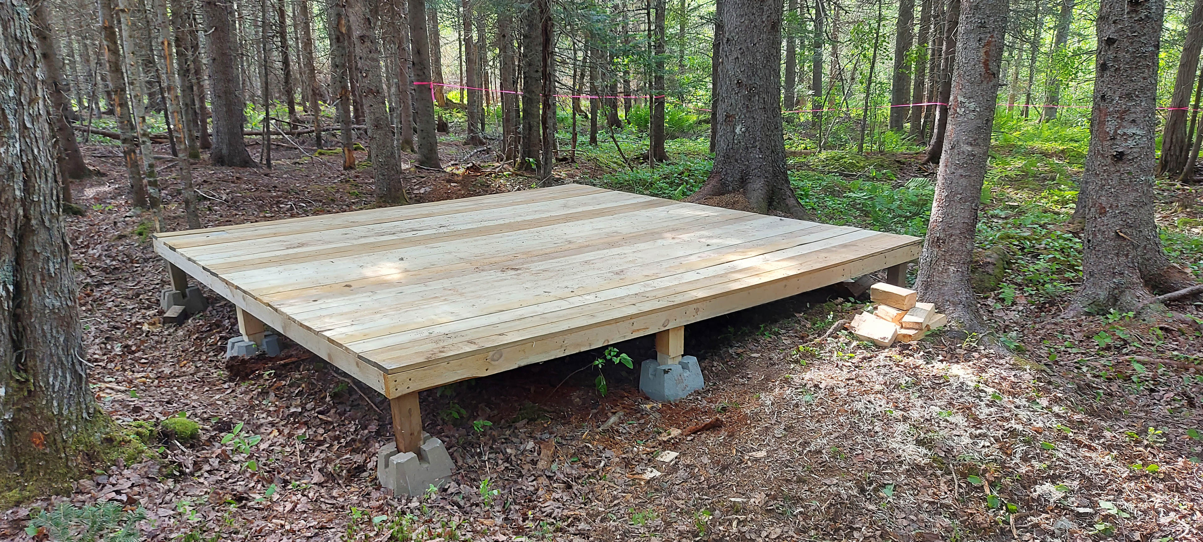 12x12 wooden platform with metal loops on a 4 corners for tie down points . Please do not nail or peg to the platform 