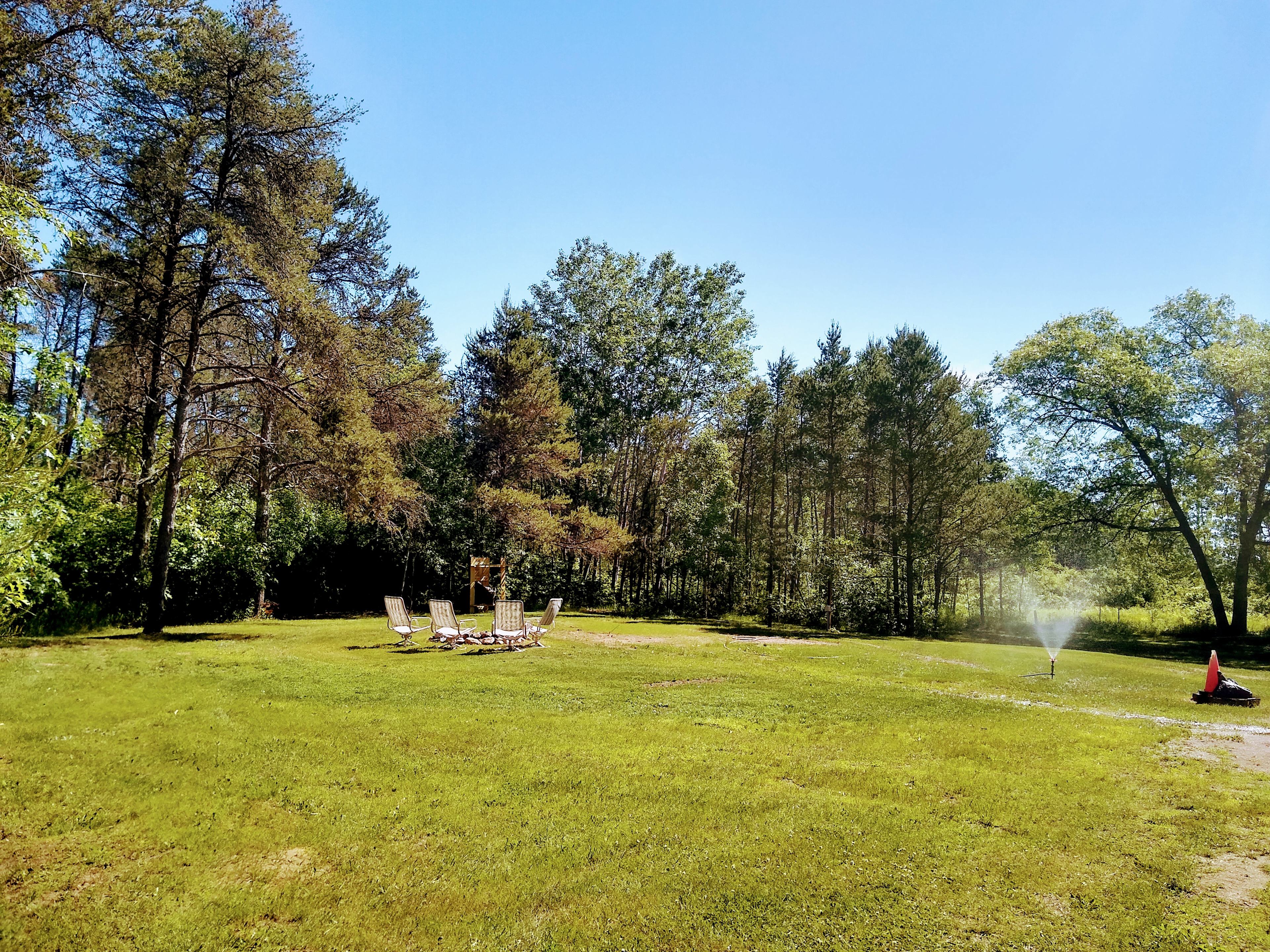 standing in back of site looking toward the road. Driveway and the garage to the right.  