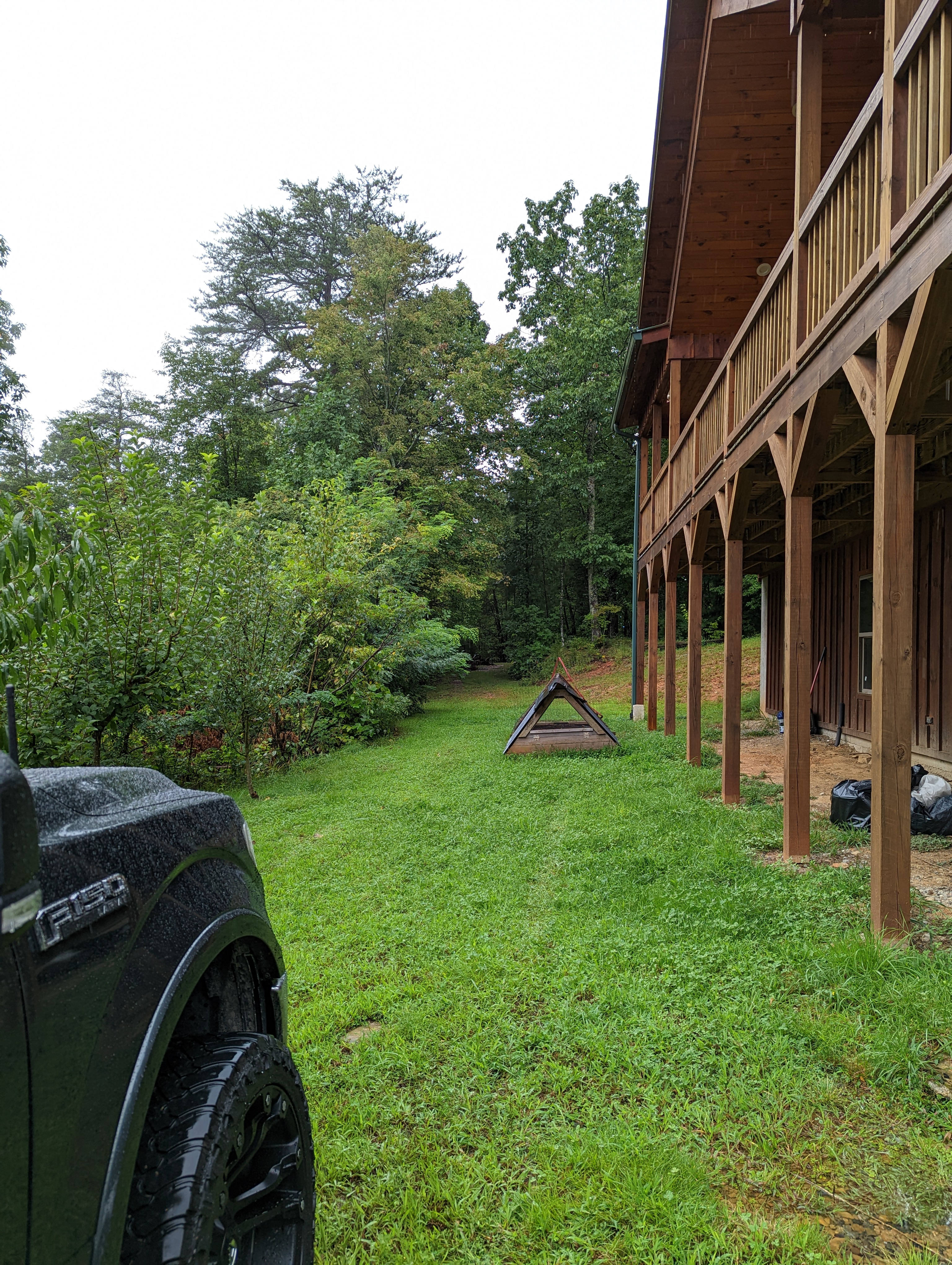Standing next to where you park looking past the house towards the trail to get to the site