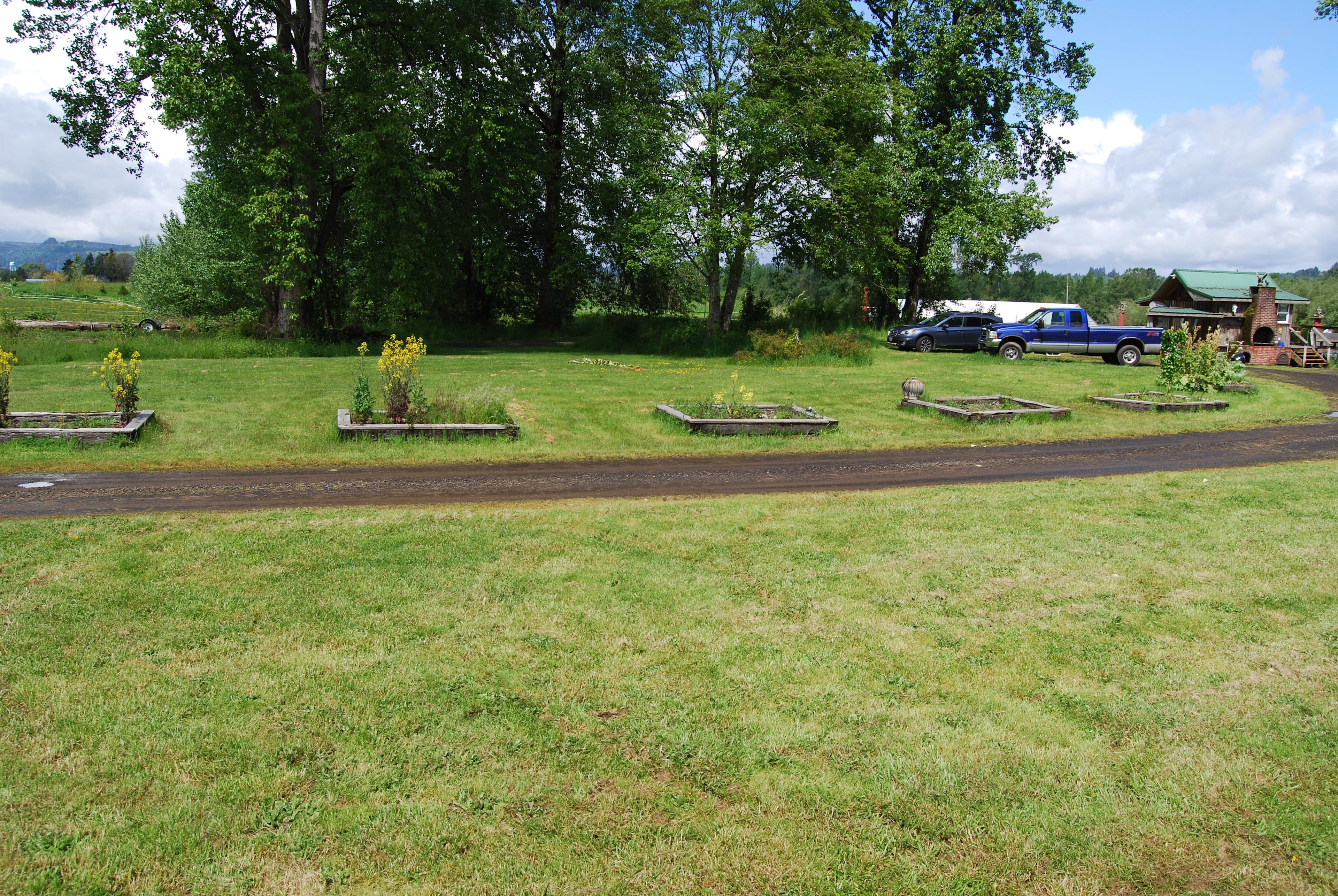 Raised vegetable beds line the grassy spaces