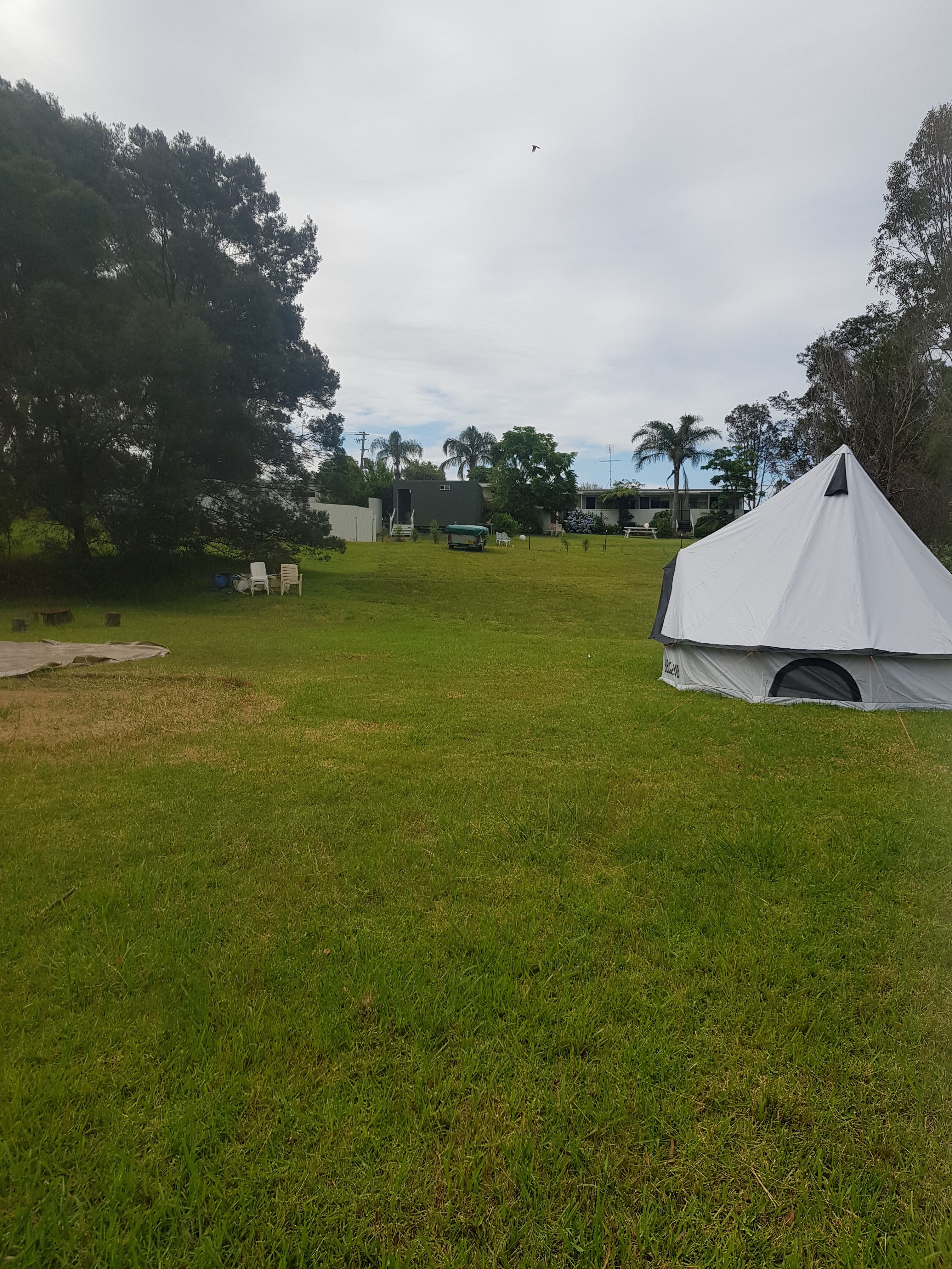 This is the large unpowered site.
Pictured is a 16ft bell tent and to the left you can see a grass mark from a 20 ft bell tent and there is still plenty of room.
The closest camper is up the hill where you can see a camp trailer. 
Behind the camp trailer is the amenities block