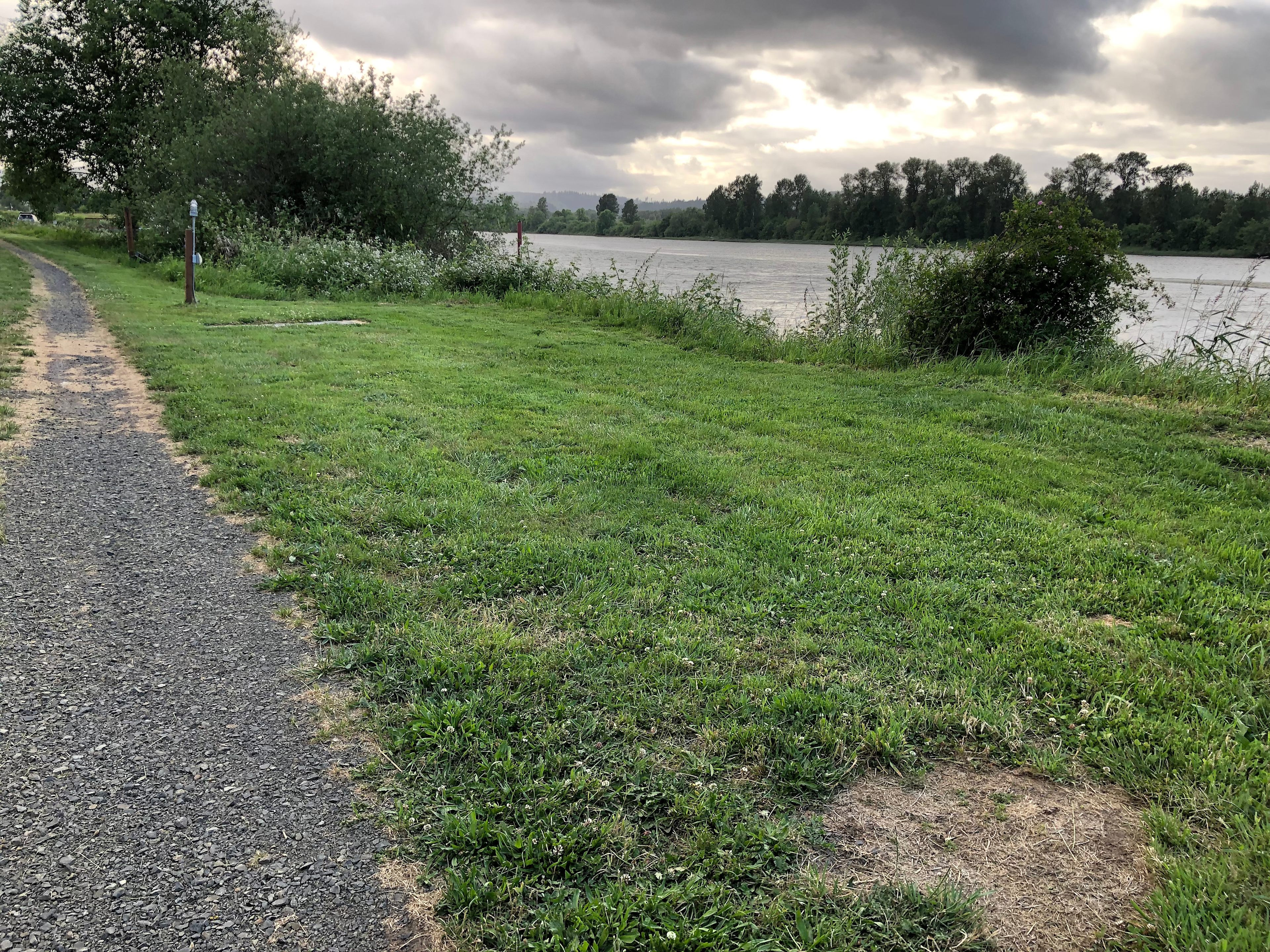 This campsite is rather large and is perfect for an RV.   There is gravel under the grass. Lots of sun but no shade.  This site can also get quite windy in the afternoon.  This site is on the river and has 110 electricity and water.  You have to back in or out.