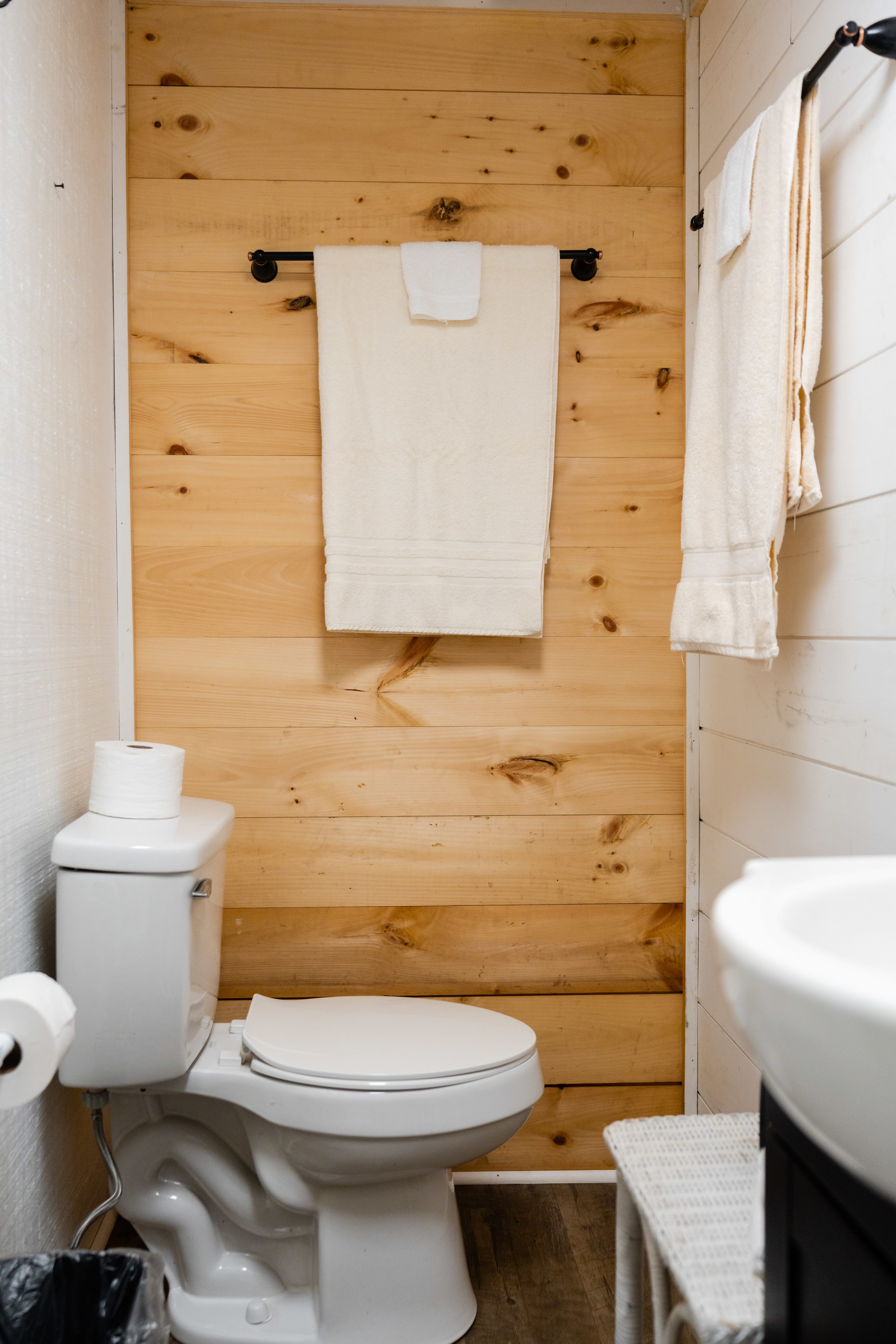 Toilet across from the shower. There is a closing door from the bedroom to the bathroom