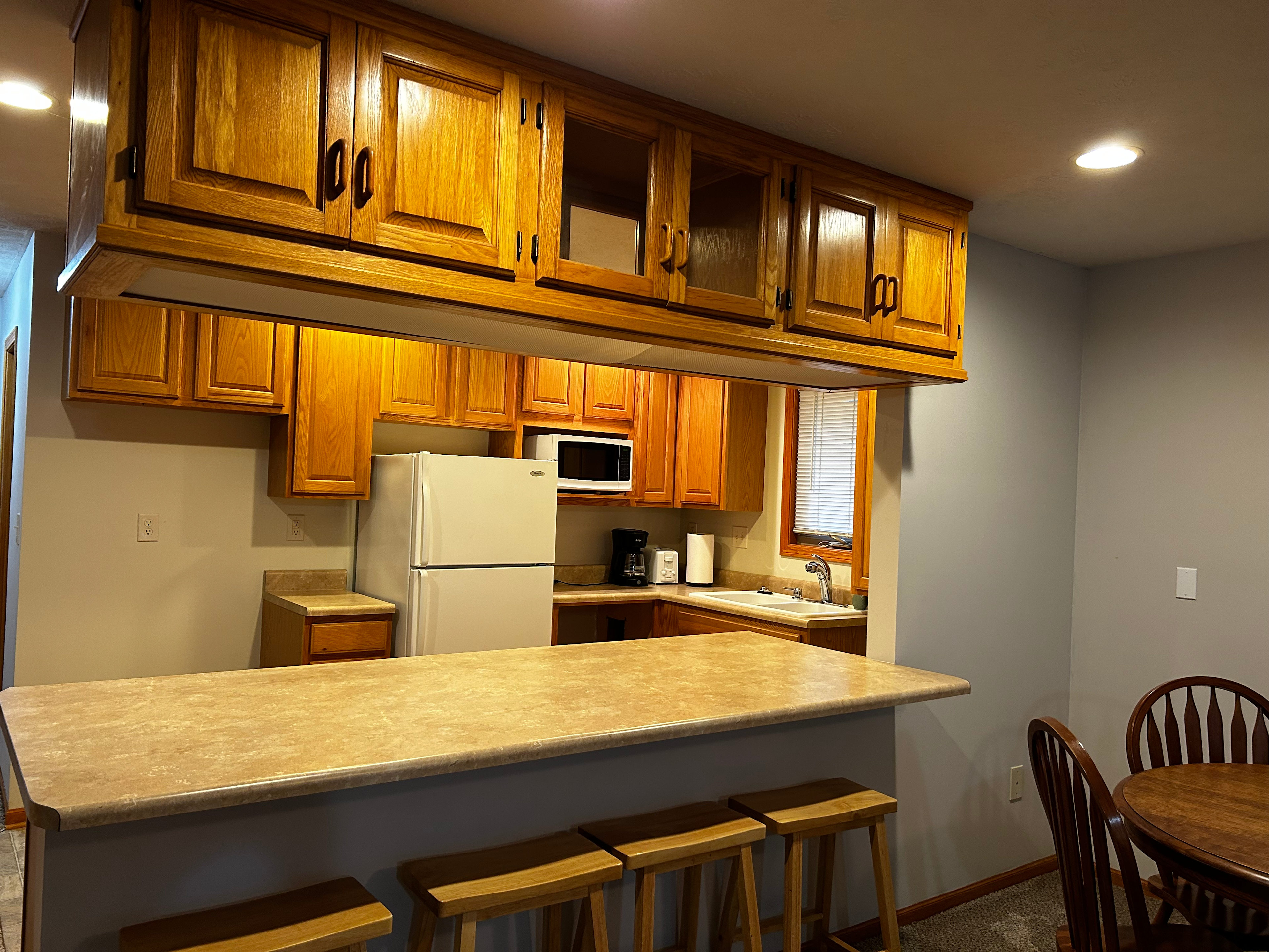 Kitchenette with refrigerator, coffee maker, toaster, and microwave.