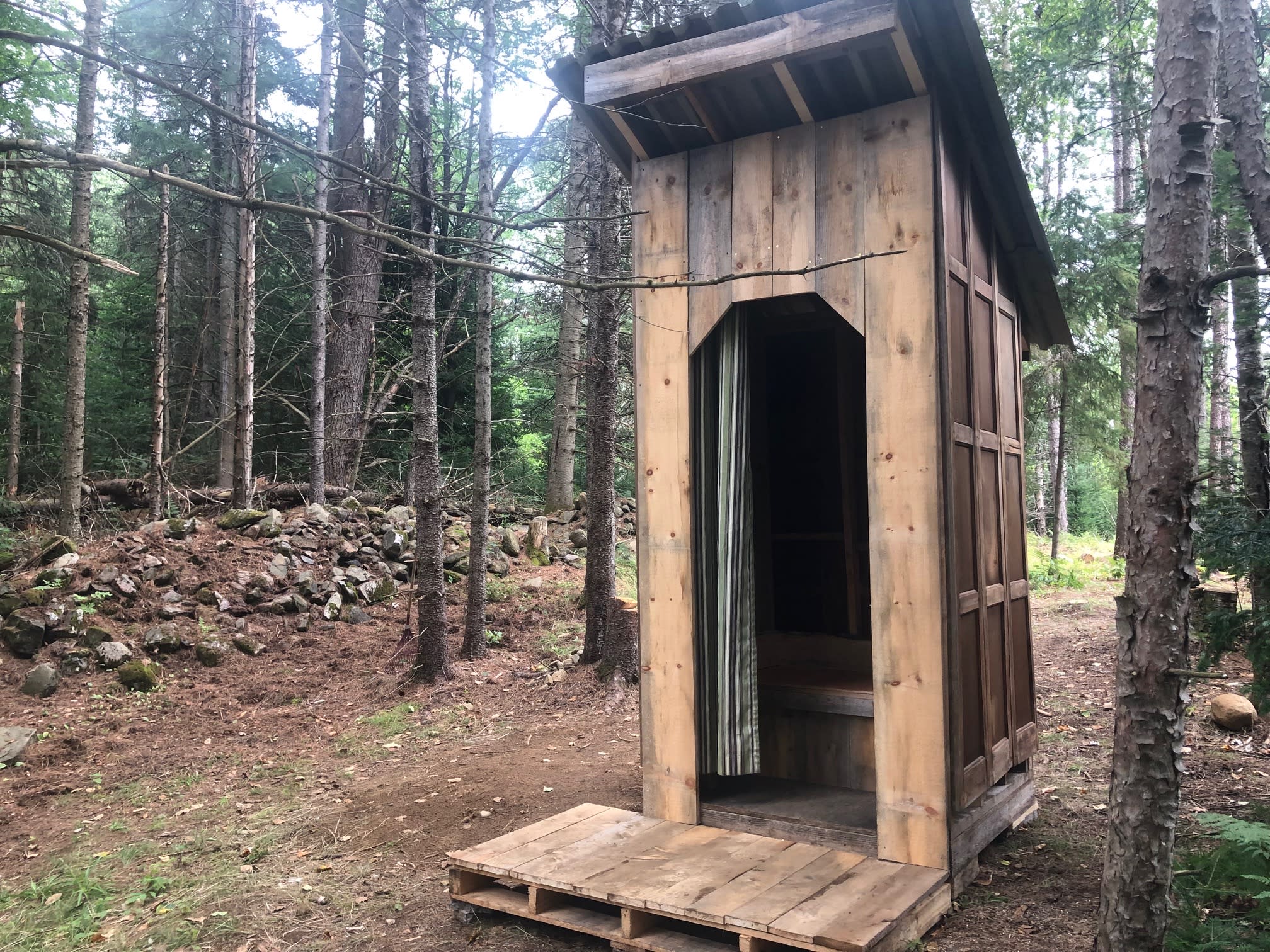Outhouse facing pond. Heritage stone row to left.