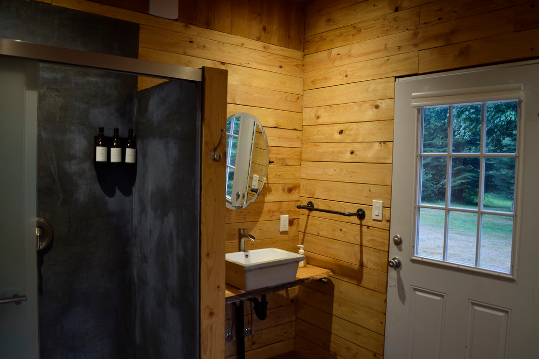 Brand new custom built old style bathroom with large dyed cement shower, sink and composting toilet