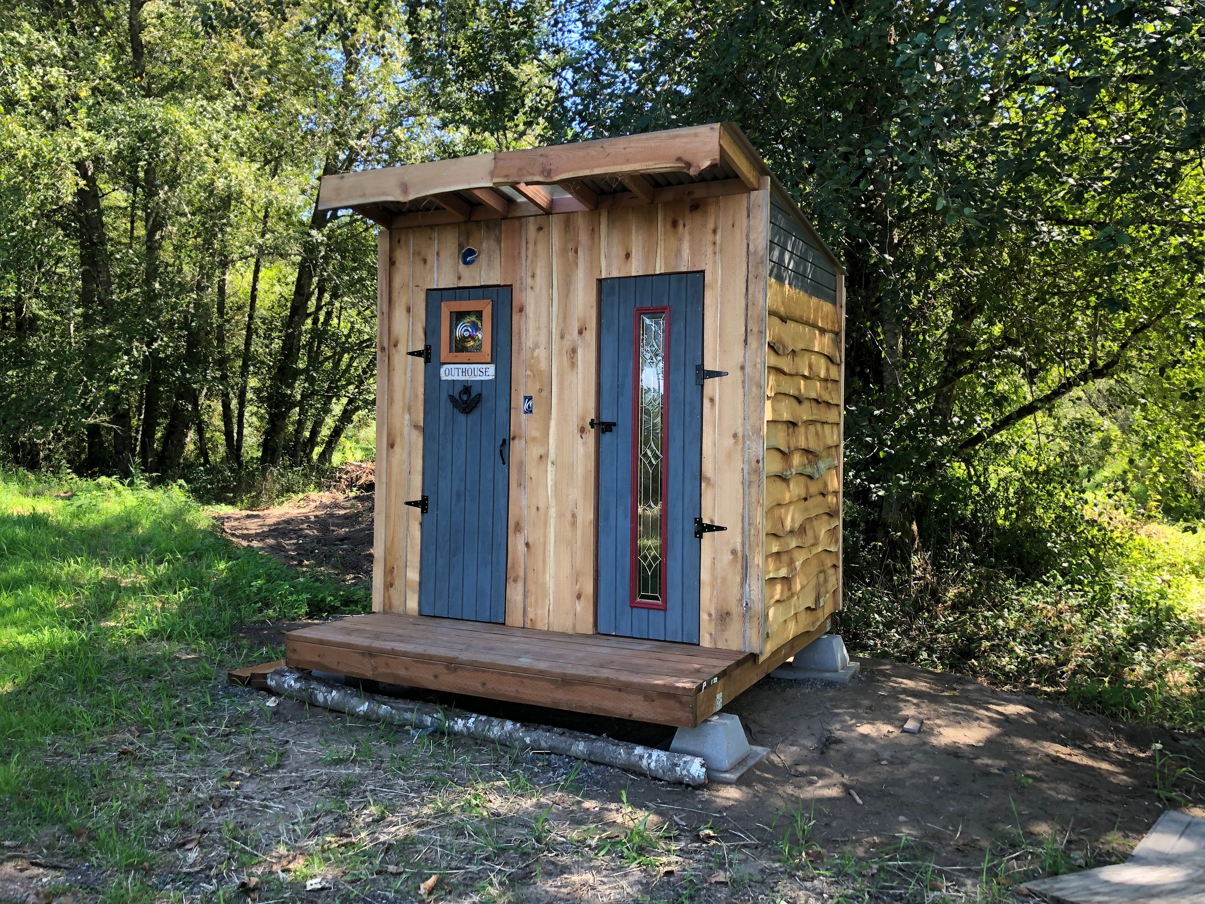 The new outhouse and storage room is located right next to the tiny cabin.