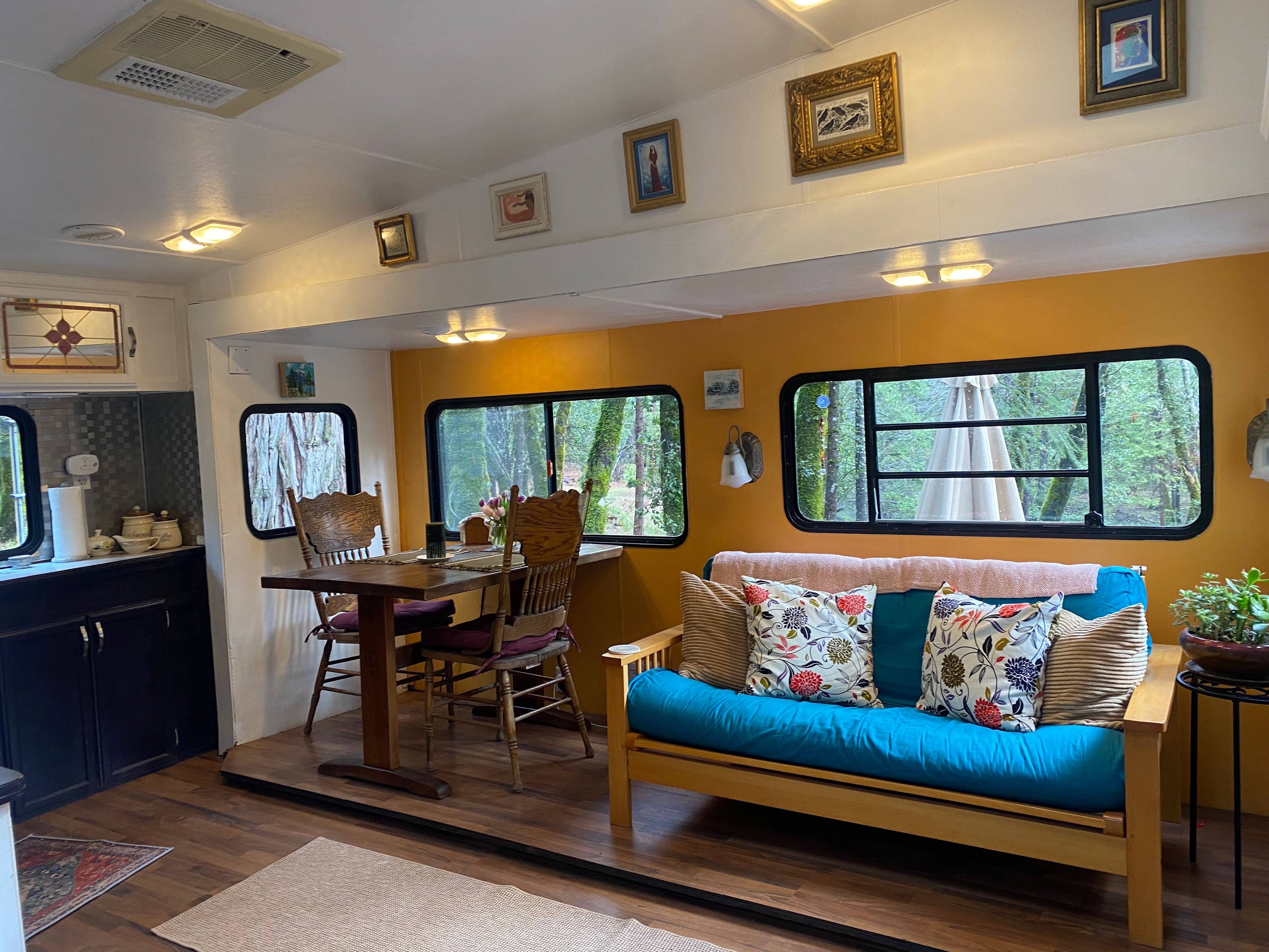 Colorful living area. The futon can provide extra sleeping area.  Dining area provides a beautiful views of the pond, stream and woods. 